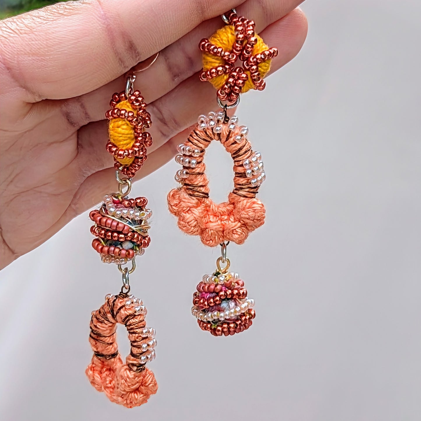 Discover a beautifully handcrafted pair of Indian-style earrings in shades of peach, orange, bronze, and rose gold, exclusively from sustainable UK brand Mayaani Jewellery. These earrings feature signature concept beads, expertly made by in-house artisan Megha from leftover materials from the jewellery-making process. Celebrating artistry, beauty, and sustainability, they are perfect for weddings and special occasions, while also making a stunning statement in sustainable fashion for everyday wear.