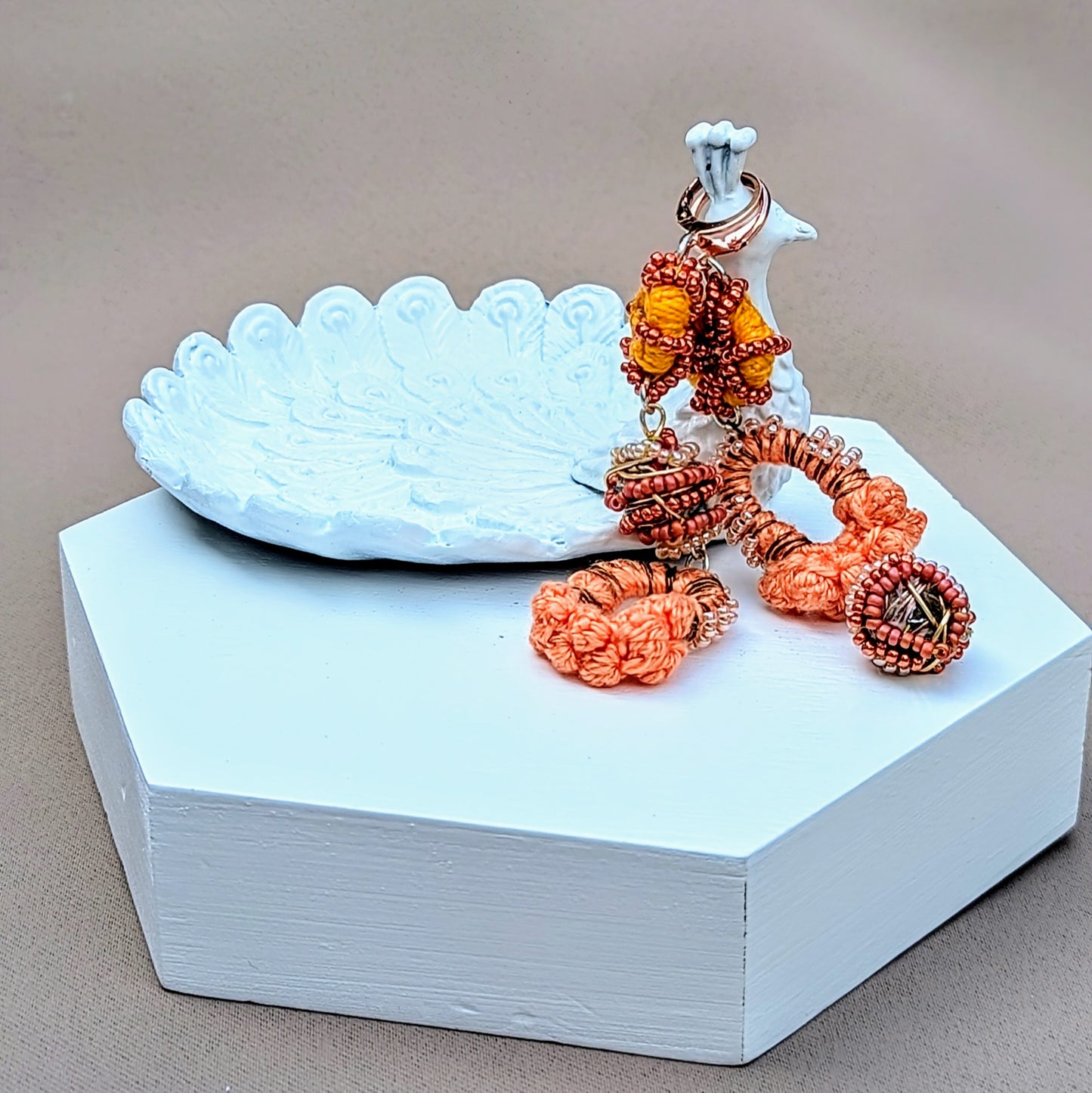 Embrace a uniquely handcrafted pair of Indian-style earrings in shades of peach, orange, bronze, and rose gold, exclusive to sustainable UK brand Mayaani Jewellery. These earrings are adorned with signature concept beads handmade by in-house artisan Megha, crafted from the remnants of the jewellery-making process. Celebrating artistry and sustainability, they are perfect for weddings and special occasions, while also delivering a stunning sustainable style statement for everyday use.