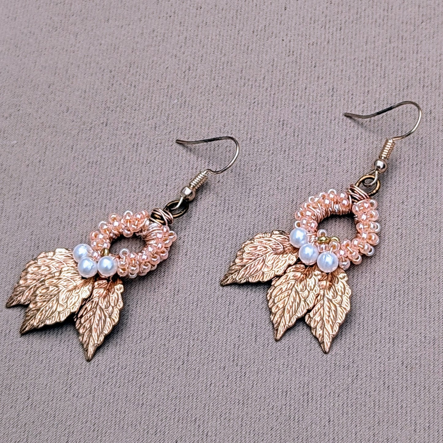 Limited edition Indian Boho earrings by UK brand Mayaani Jewellery, featuring gold-plated leaves, delicate hand wire work and beadwork. The earrings highlight hand-crocheted peach beads and white seed pearls, merging traditional techniques with contemporary bohemian aesthetics in a strikingly beautiful pairing perfect for everything from occasion to everyday wear.