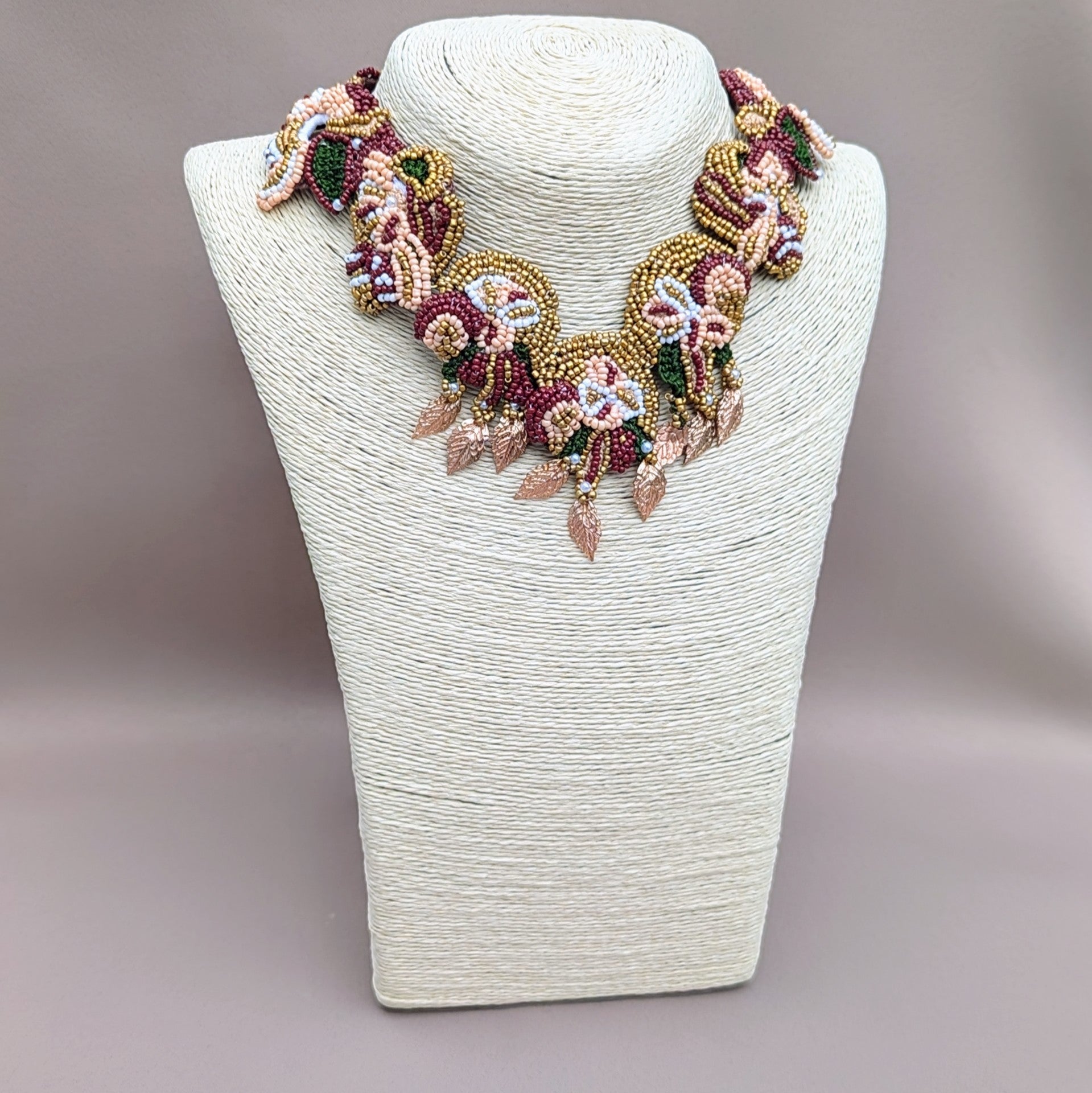 A unique one of a kind expertly handcrafted Indian bridal necklace, echoing cultural bridal traditions, featuring red, gold, green, brown and pearl tones by sustainable UK designer brand Mayaani Jewellery. Featuring a detachable centrepiece and custom-made chain, this piece offers versatile wear beyond your wedding day. Crafted with traditional artistry, this statement piece is perfect for discerning clients seeking high-end, culturally-rooted jewellery.