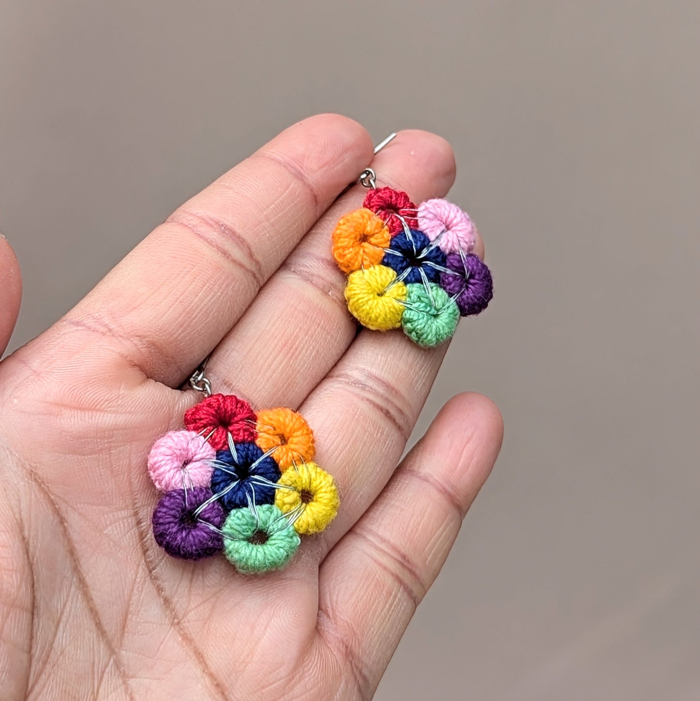 Delight in the beauty of a circular rainbow with this handcrafted pair of earrings, exclusively from the sustainable Indian brand Mayaani Jewellery UK. They offer a vibrant pop of color that instantly elevates your mood and style! Featuring hand-crocheted circles expertly wrapped in silver-plated copper wire, these bold earrings are finished with stainless steel hooks for added durability.