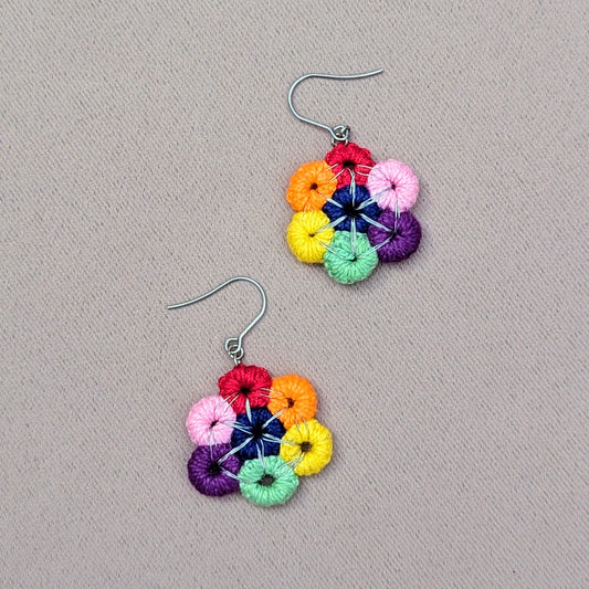 Experience the bliss of a circular rainbow of bright beautiful colours in this handcrafted pair of earrings exclusive to sustainable Indian brand Mayaani Jewellery UK. The perfect splash of colour to lift your mood and your daily look in an instant! Featuring hand crochet circles hand wire wrapped in silver plated copper wire to create a bold circle finished off with stainless steel earring hooks.