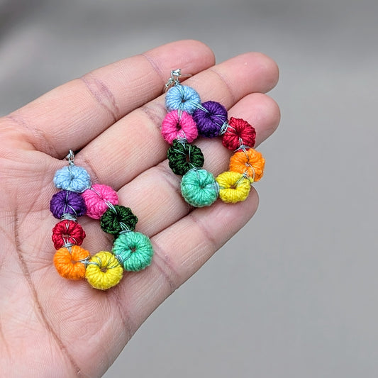 These artisan teardrop-shaped rainbow earrings by sustainable UK designer and artisan Megha of Mayaani Jewellery are beautifully handcrafted, featuring a variety of hand-crocheted and hand-wire-wrapped circles in an array of colors. Each circle is intentionally crocheted by hand and wrapped in high-quality silver-plated copper wire before being thoughtfully arranged to create a rainbow teardrop design. The delicate sterling silver lever-back earring hooks complete this stunning piece.