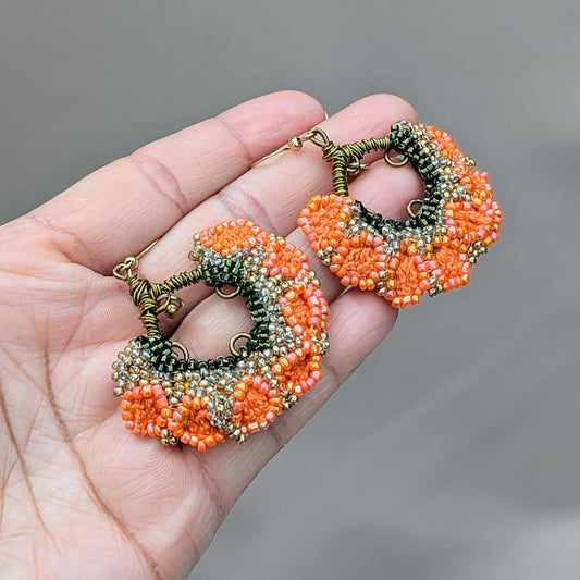 Close-up of one-of-a-kind orange, green, and gold handmade Indian jhumka earrings sustainably crafted by Mayaani Jewellery UK.