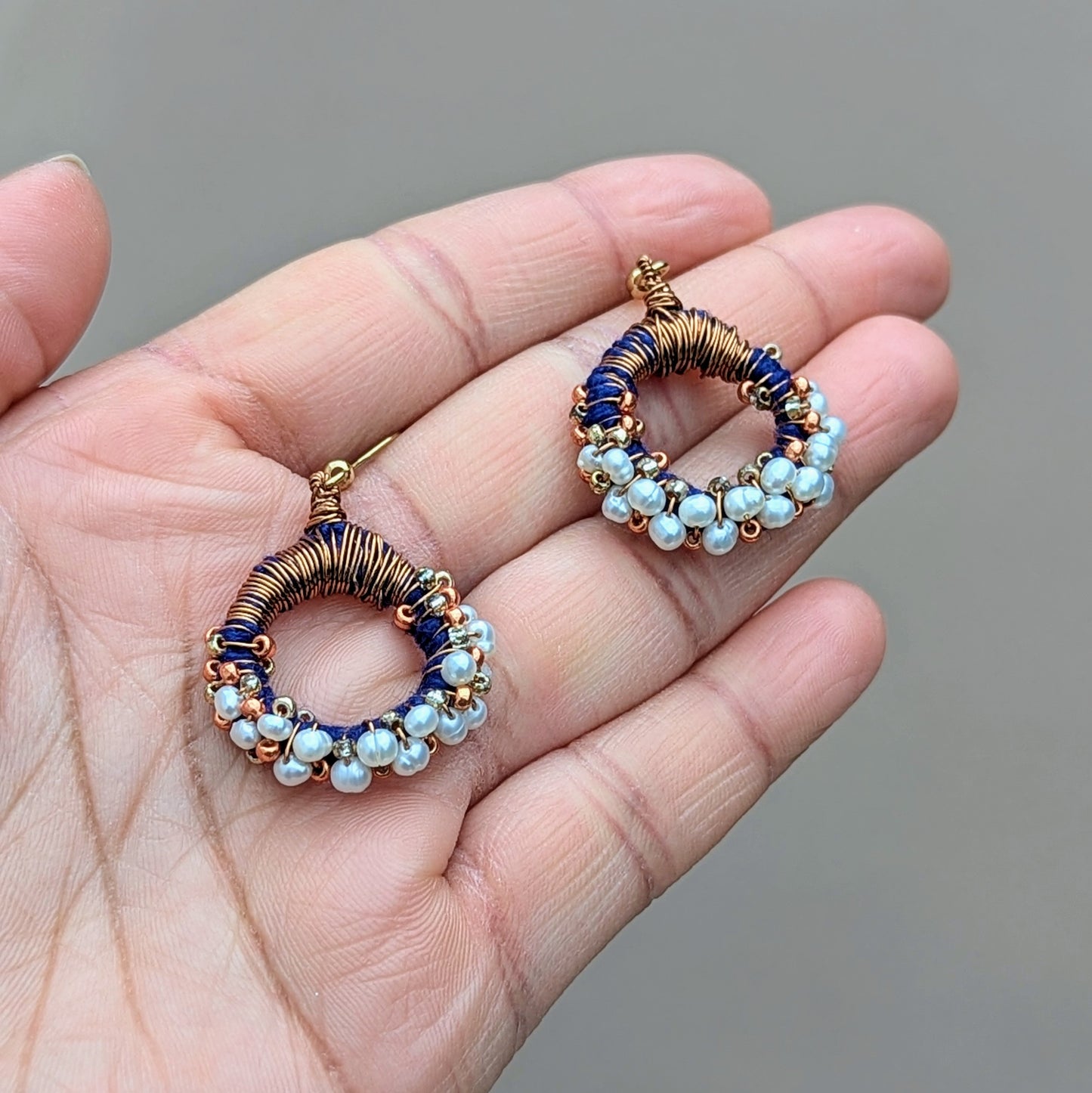 Elegant artisan hoop earrings in bronze copper and blue with freshwater pearls, slow-made in the UK by Mayaani Jewellery.