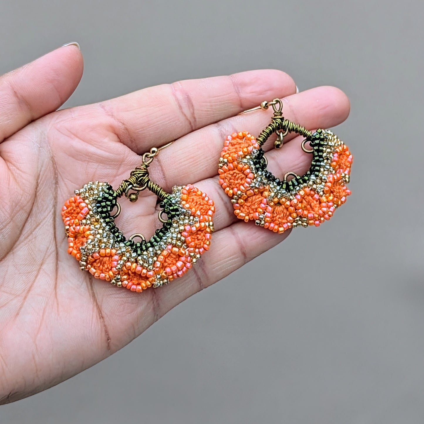 Handcrafted orange and coral glass beaded jhumka earrings with antique bronze wire and gold-plated hooks, designed by Mayaani Jewellery UK.