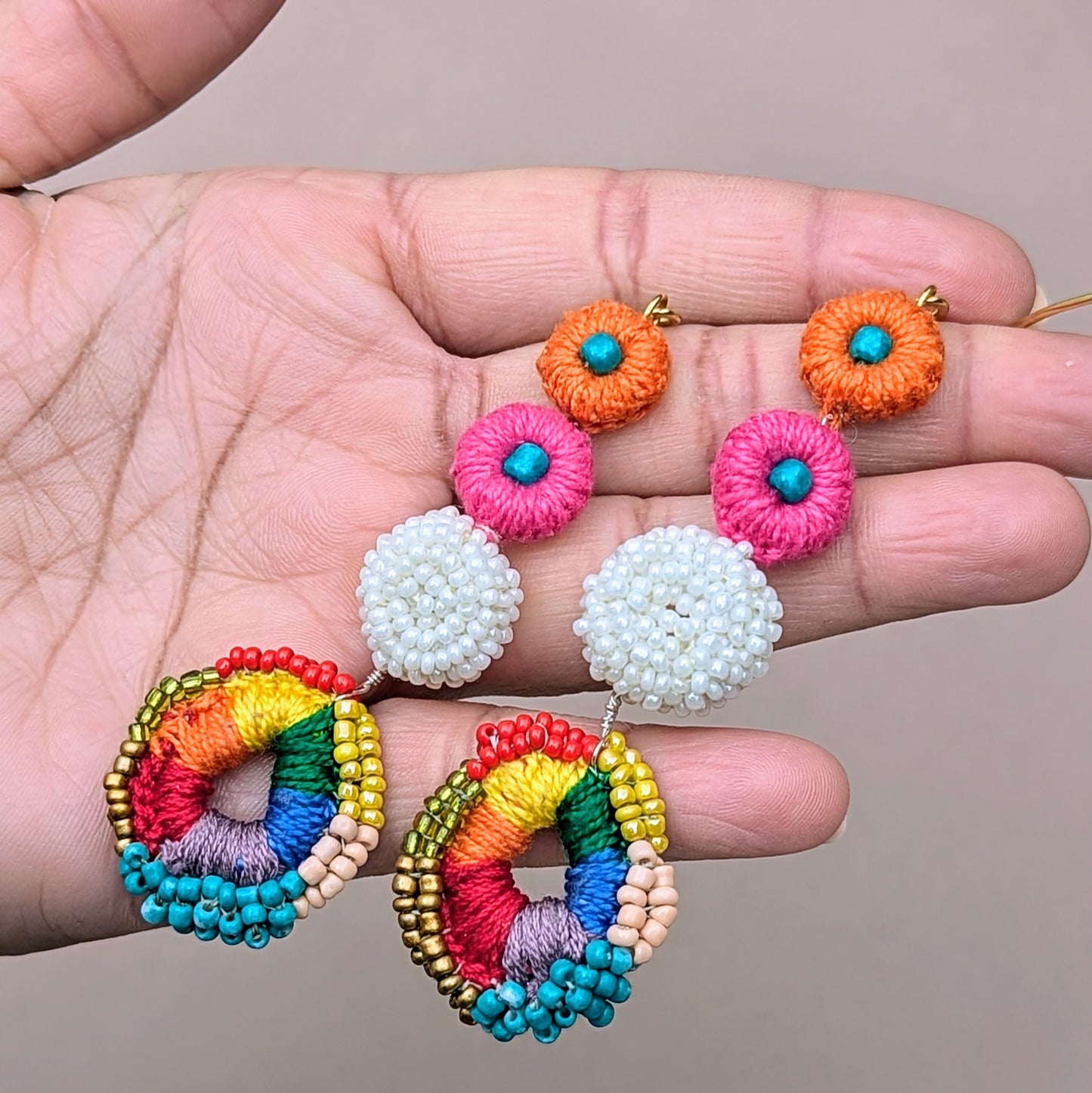 Colourful dangle earrings with layered crochet discs in pink, orange, white, and rainbow - bold, joyful design crafted by UK-based ethical jewellery brand Mayaani.