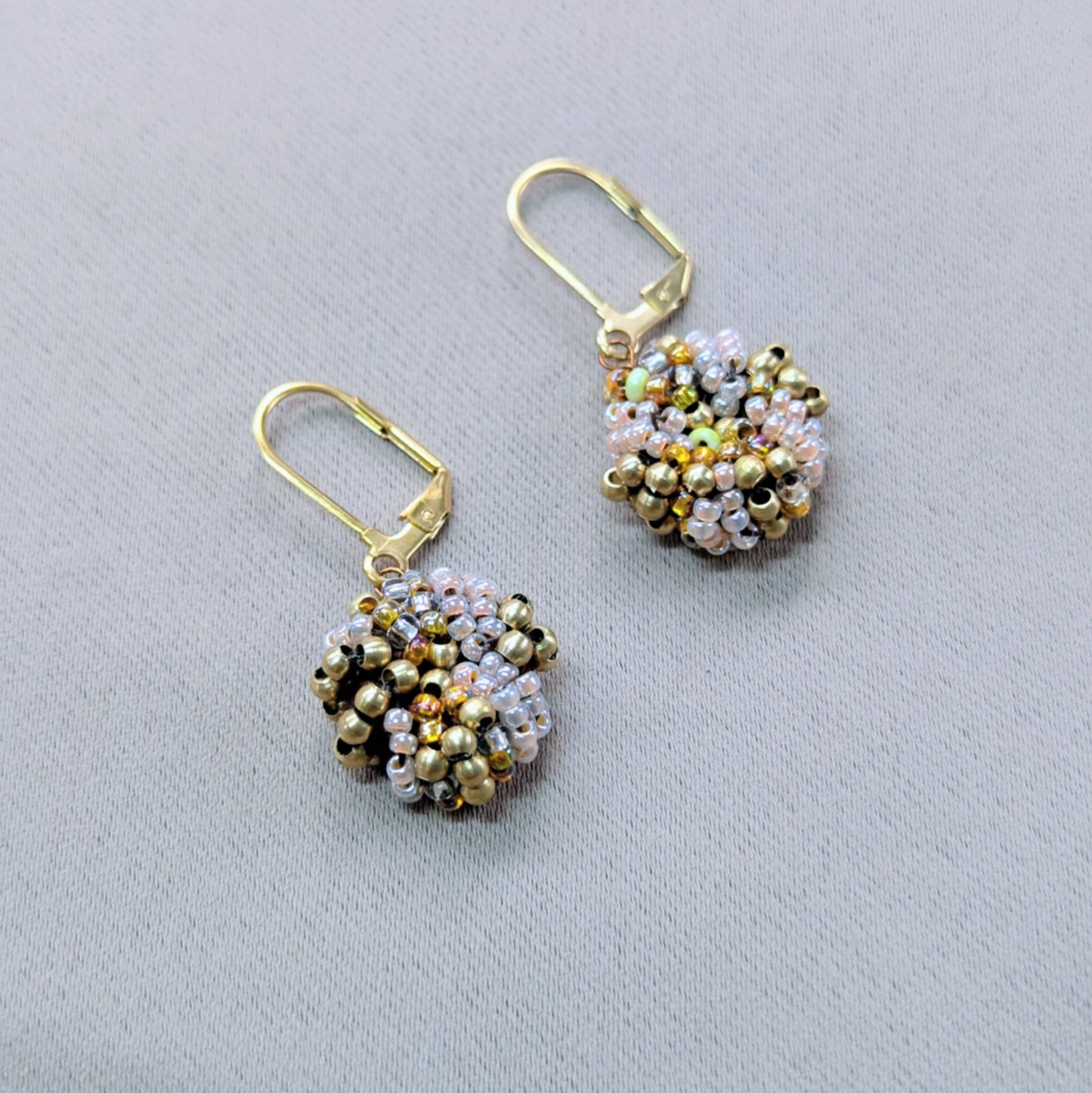 One-of-a-kind gold bead earrings symbolising wholeness and warmth.