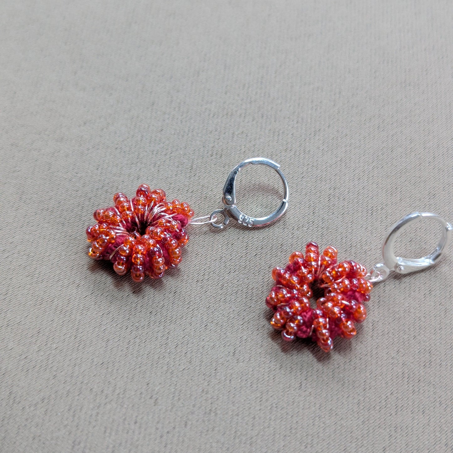 One-of-a-kind orange-red seed bead earrings radiating warmth and vibrancy.