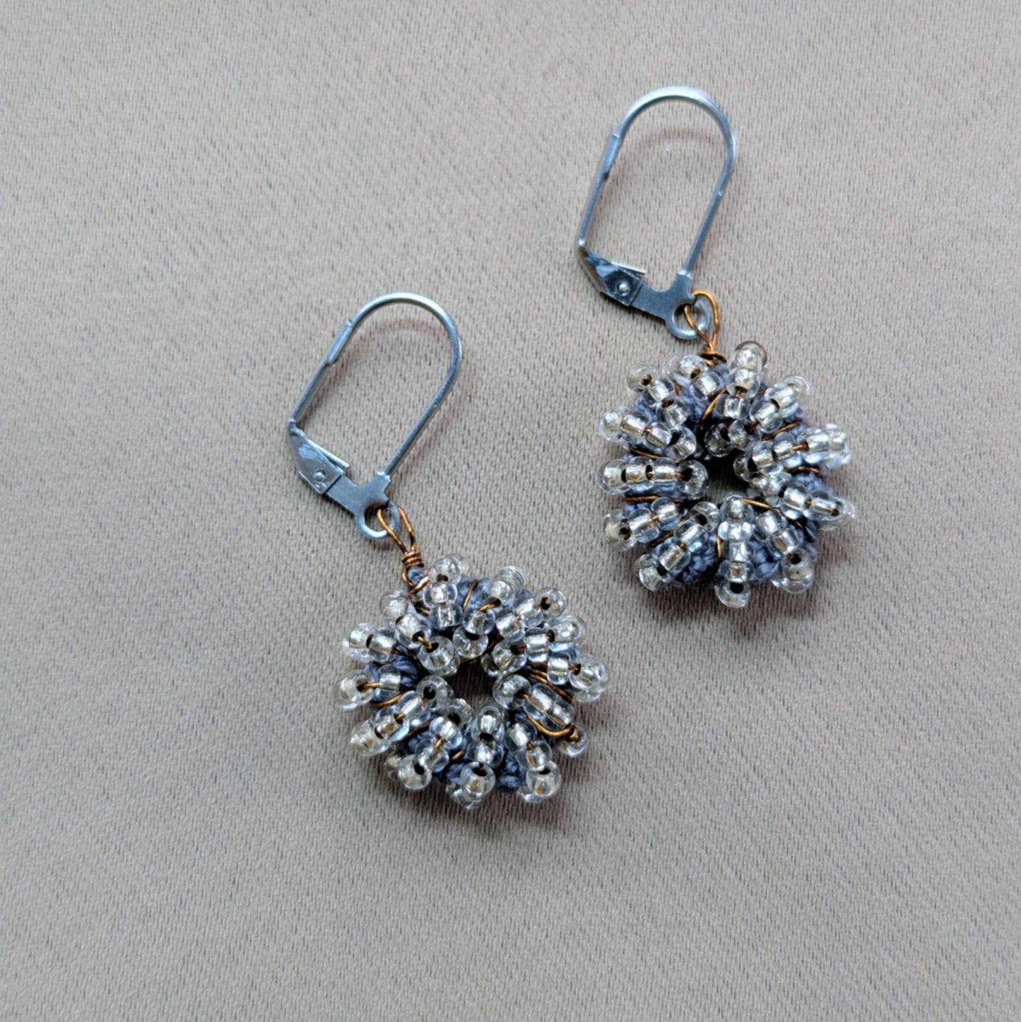 Indian artisan Megha’s handmade earrings featuring antique bronze wire and seed beads.