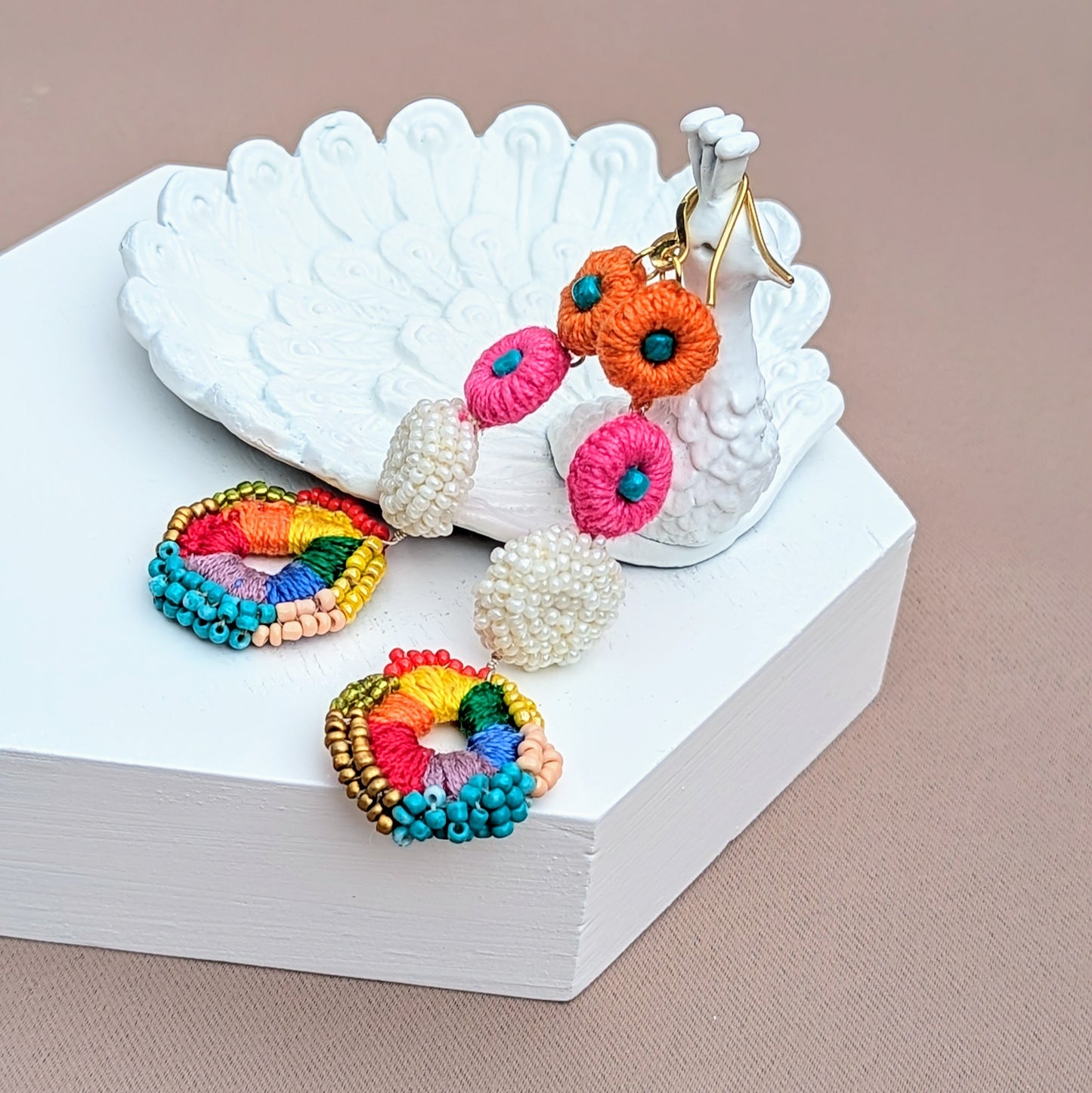 Close-up of eco-conscious rainbow crochet earrings with multi-circle drop structure, showcasing artisan beadwork and playful Indian bridal fusion style.