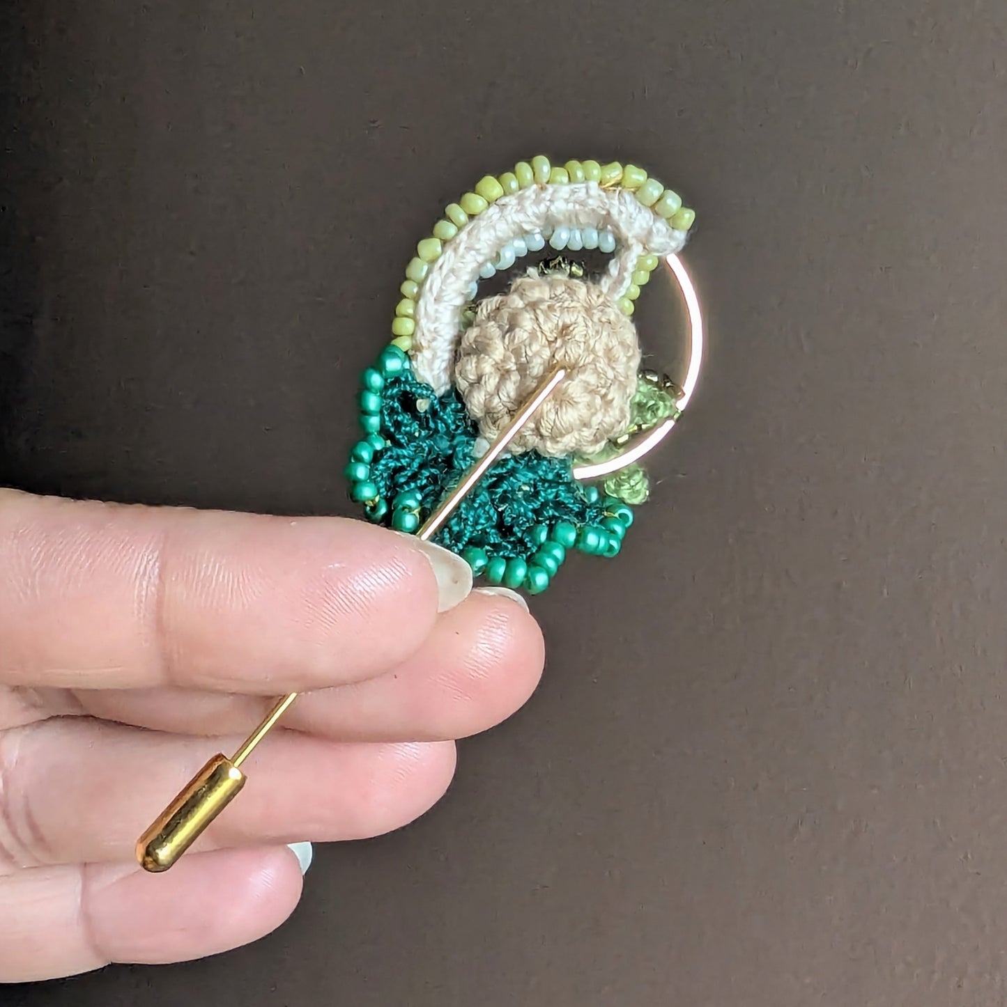 Back view of Sarika brooch showing crochet backing and gold stainless steel pin fastening.