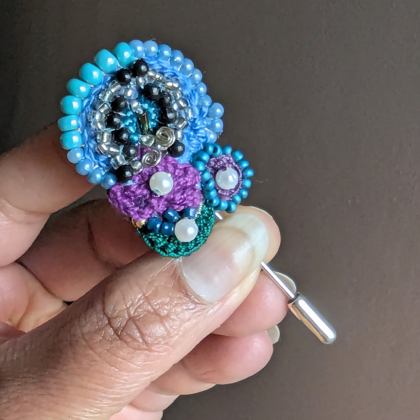 Kairavi butterfly brooch lapel hat pin close-up showing layered turquoise beadwork, silver bead accents and pearl details.