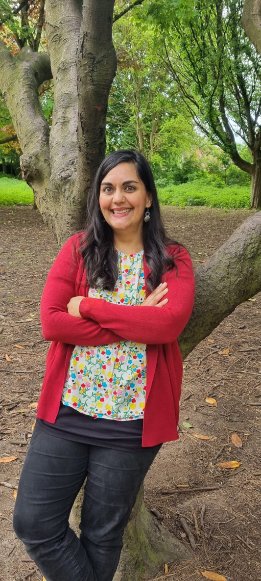A picture of the artisan behind Mayaani Jewellery posing outdoors in natural light wearing a pair of earrings handcrafted with love using her own two hands.
