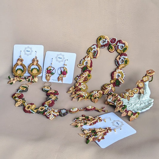 Sustainably handmade Aishwarya Indian red, green and gold designer bridal wedding occasion set exclusive to Mayaani Jewellery featuring maang tikka, earrings, 2-in-1 necklace and a 3-in-1 hand bracelet (haath phool).
