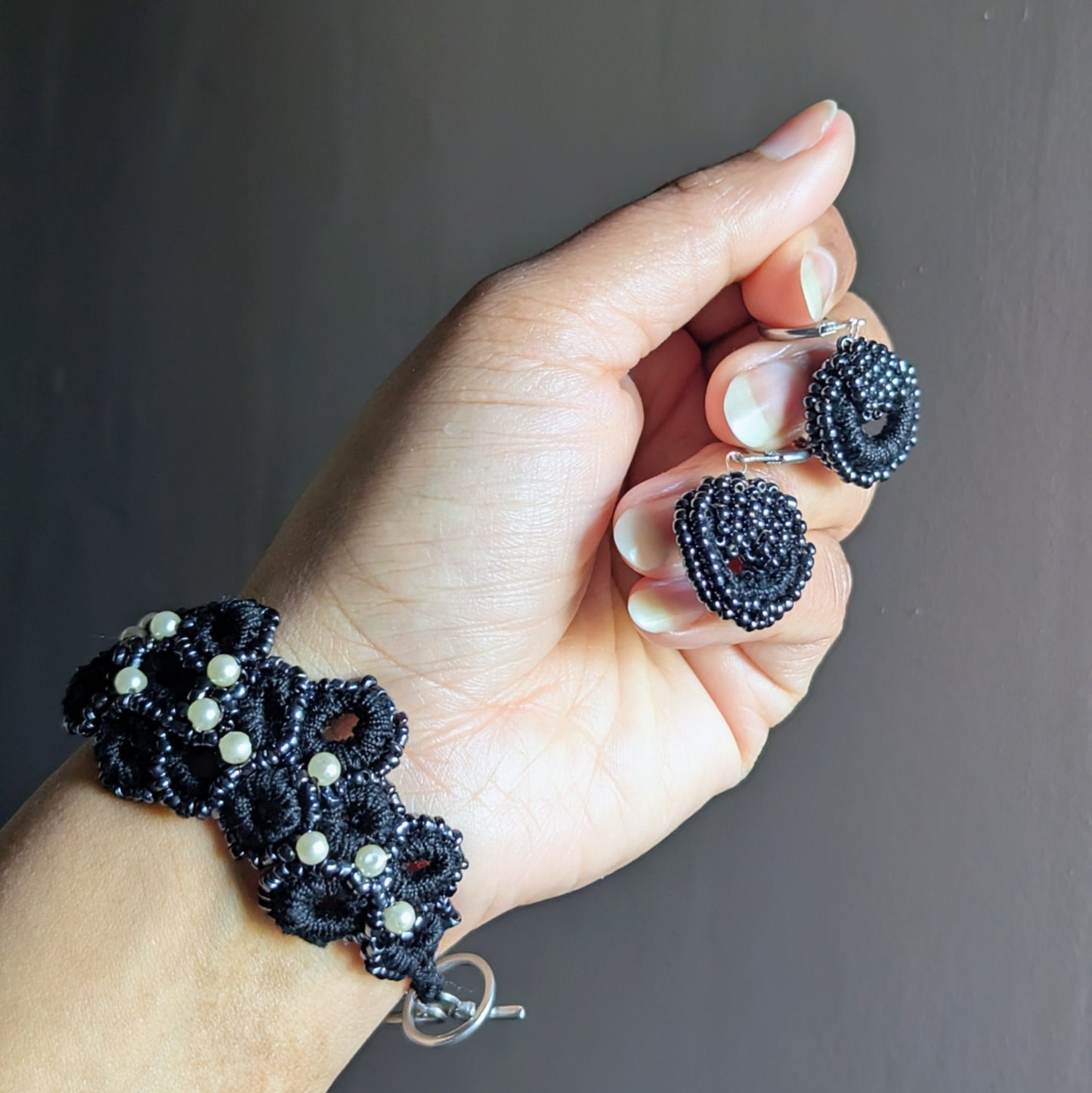 Sustainable handmade black jewellery set with crochet textures and pearl accents.