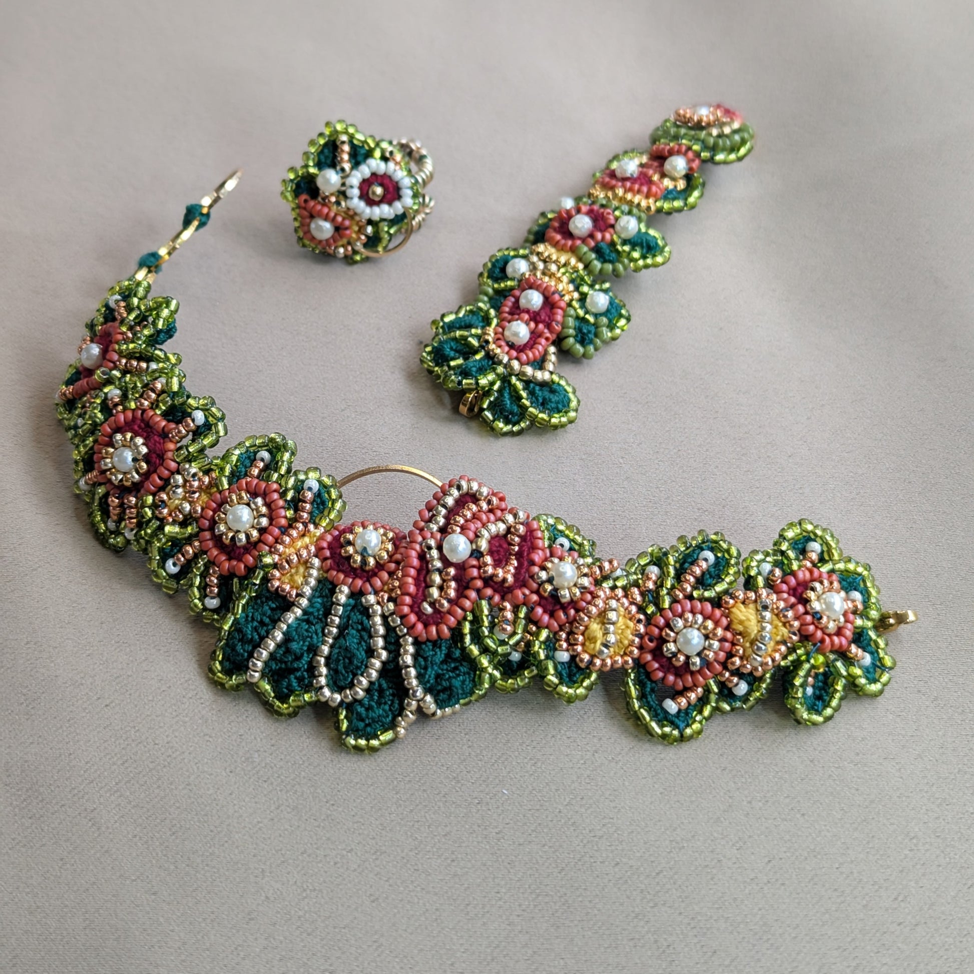 Flat lay of the Rukmini 5-in-1 Indian hand bracelet by Mayaani Jewellery UK - showing the separate elements this bracelet can transform into against a neutral fabric backdrop.