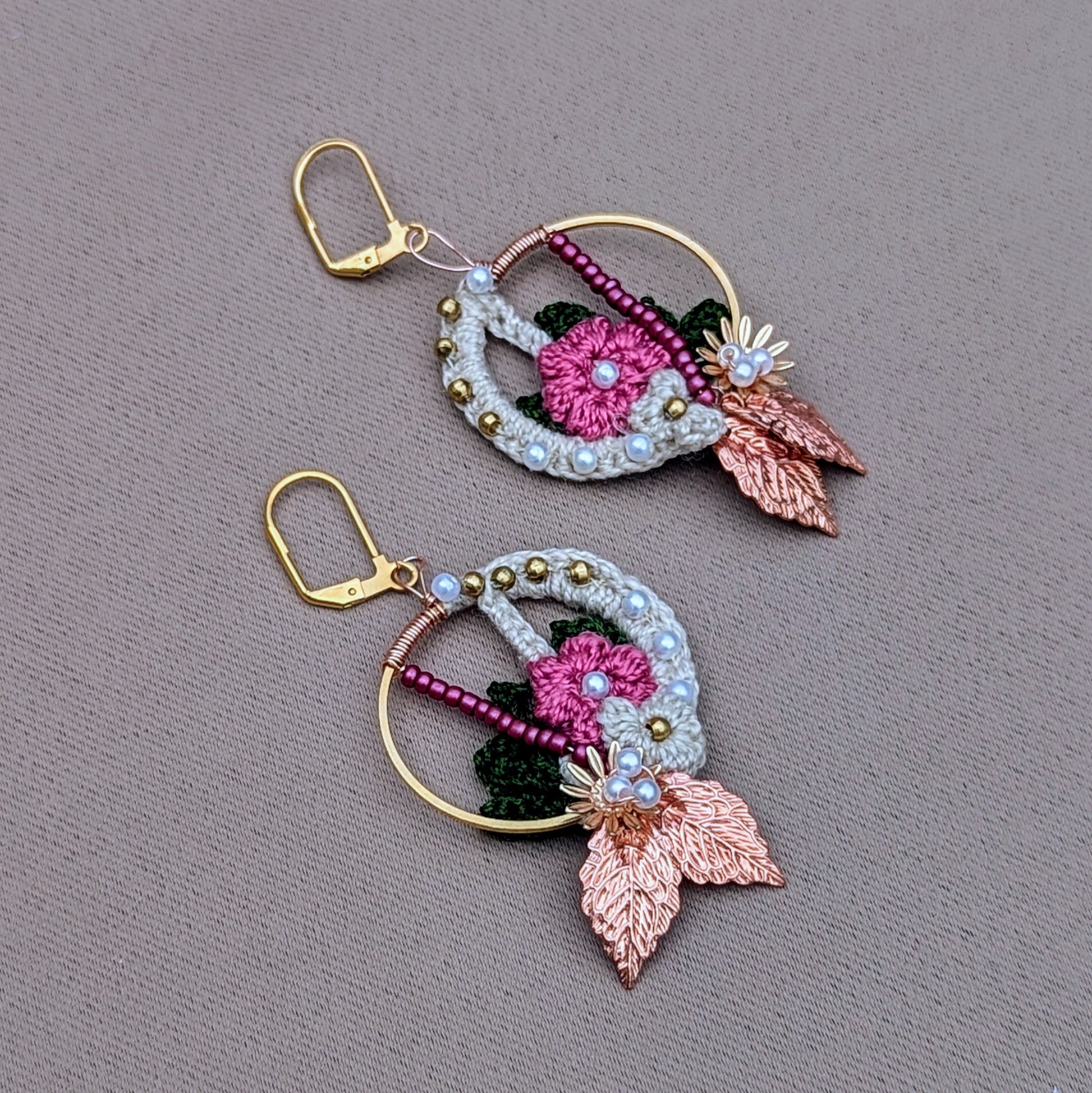 A stunning pair of handcrafted Indian-inspired earrings from Mayaani Jewellery, a sustainable UK brand. These exclusive earrings showcase an exquisite blend of cream, pink, and dark green floral and leaf motifs, adorned with solid brass, pink, and seed pearl beads. Finished with brilliant rose gold leaves and gold-plated stainless steel clasps, this lightweight accessory makes a striking statement. Ideal for weddings, special occasions, or everyday elegance, they combine artistry and versatility.