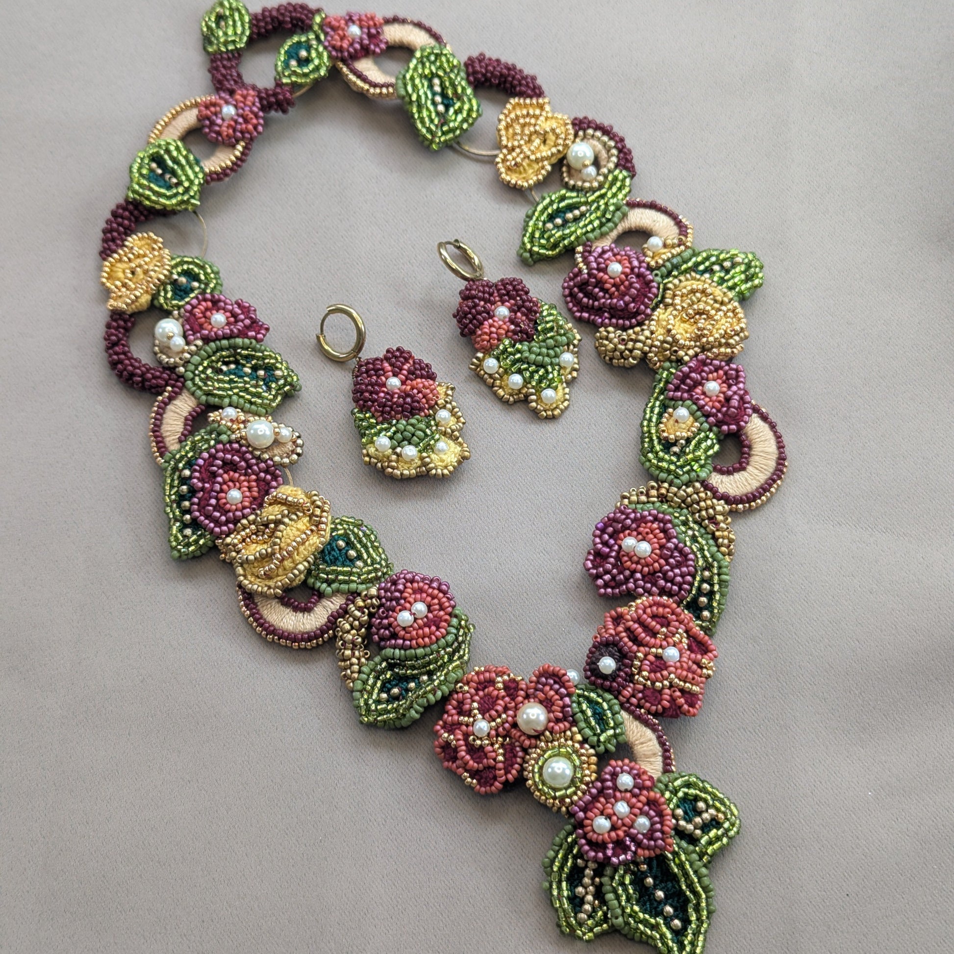 Rukmini UK artisan crafted earrings and statement necklace featuring botanical motifs by Mayaani Jewellery - conscious luxury handcrafted in burgundy, olive green and gold.