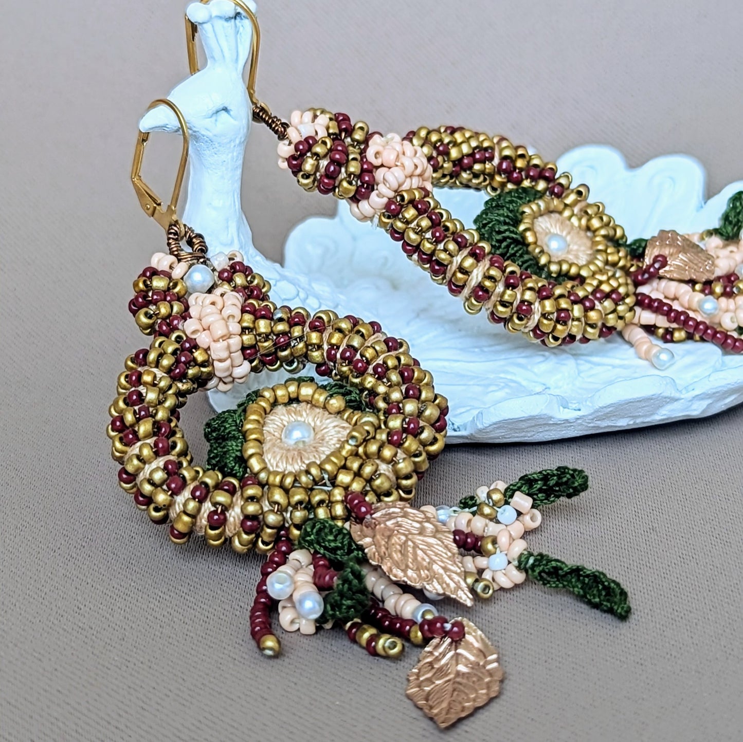 Side view of a red, green and gold botanical inspired couture pair of Aishwarya statement earrings consciously and sustainably made at Mayaani Jewellery UK.