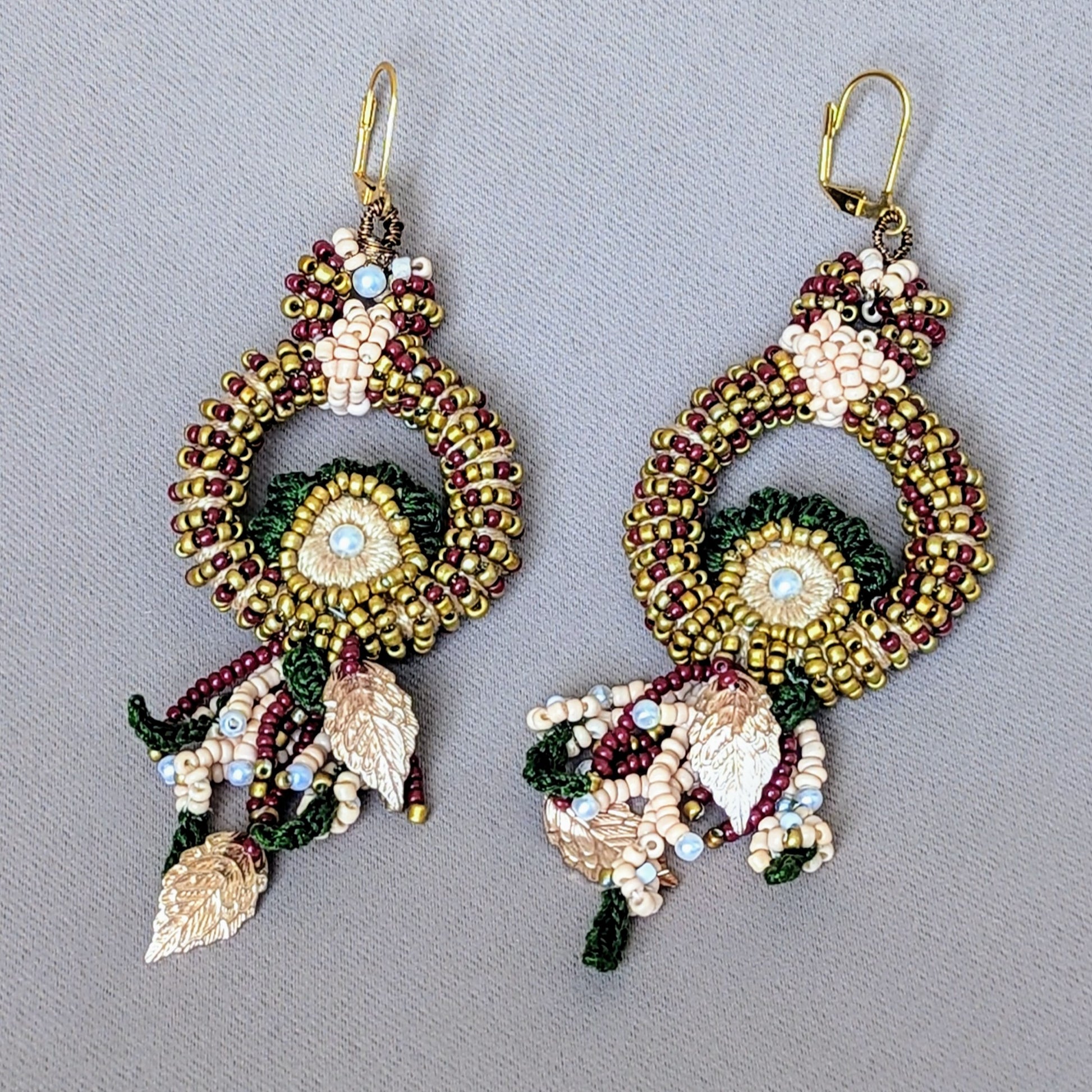 Flat lay of statement bead crochet handmade Aishwarya red green gold bridal earrings made for sustainable UK brand Mayaani Jewellery.