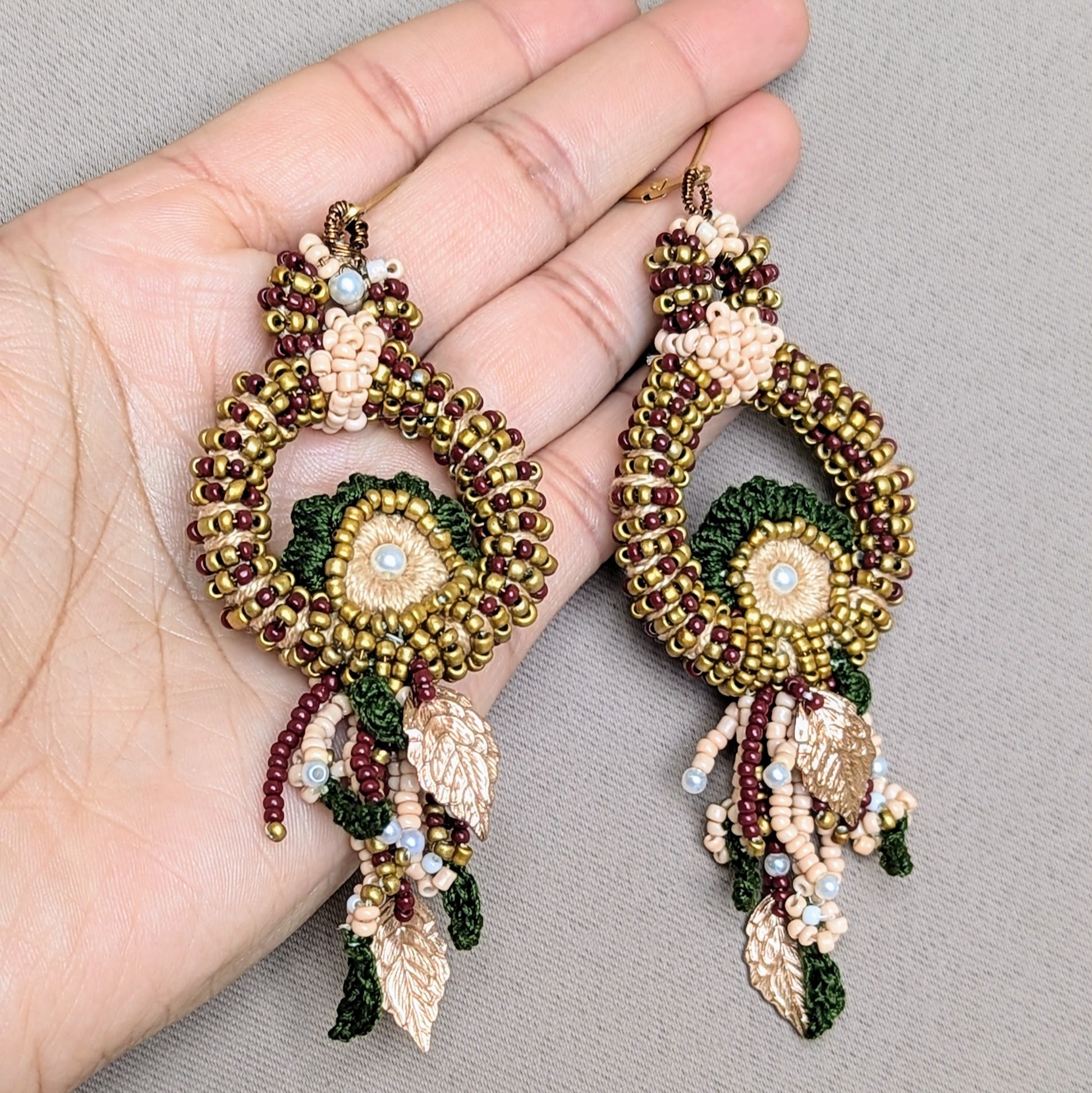 Hand holding Aishwarya earrings highlighting elegant length, lightweight design, and six-hour artisan craftsmanship.