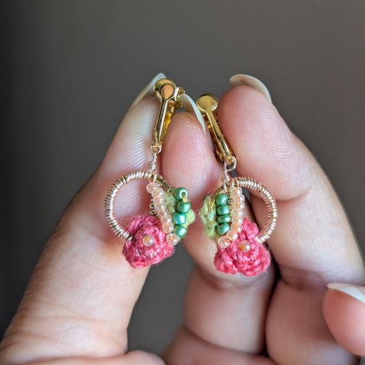 Anandi lightweight clip-on earrings by Mayaani Jewellery featuring rose pink crochet flowers with an abundance of rose gold plated wire wrapped around a gold hoop and chartreuse see bead detailing.