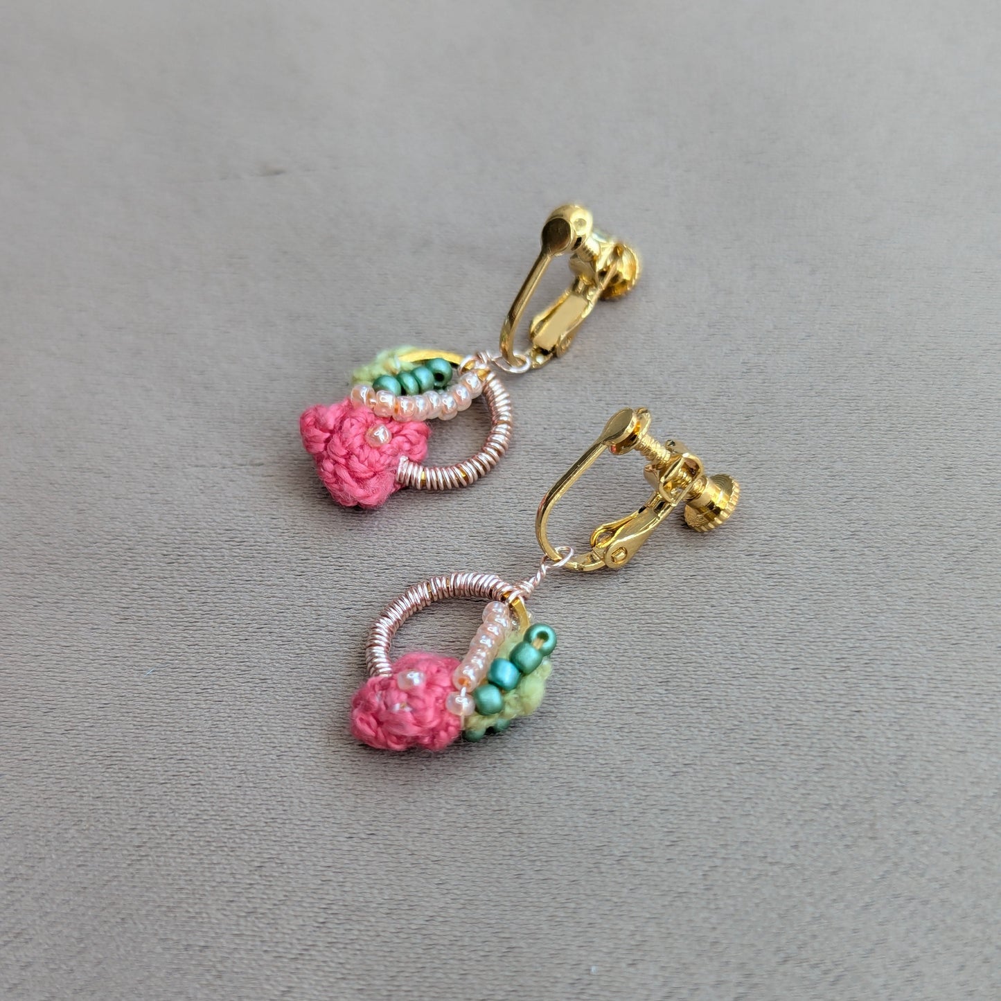Flat lay of Anandi handmade pink, green and gold luxury clip-on earrings - one of a kind joyful luxury by UK indian designer and artisan Megha of Mayaani.