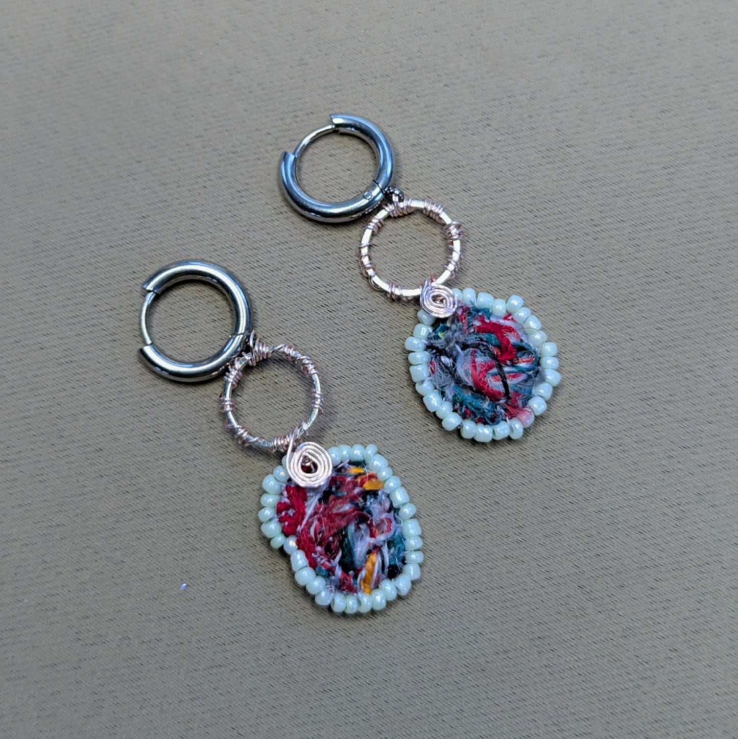 Flat lay of Anvaya handmade scrap bead earrings showing mint green glass seed bead edging.