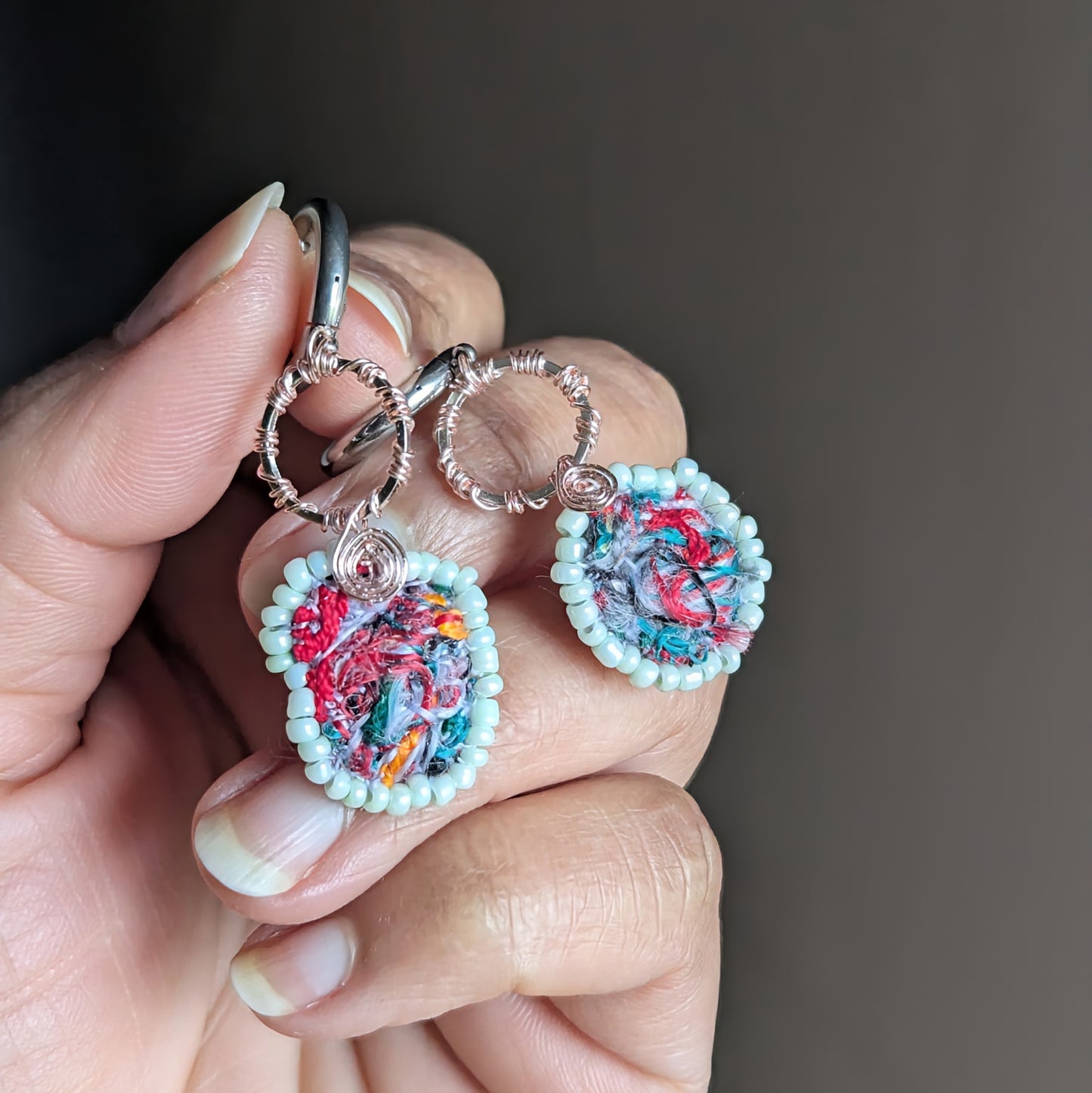 Anvaya asymmetric scrap bead earrings with mint green glass bead border and textile art centres, handcrafted in the UK.