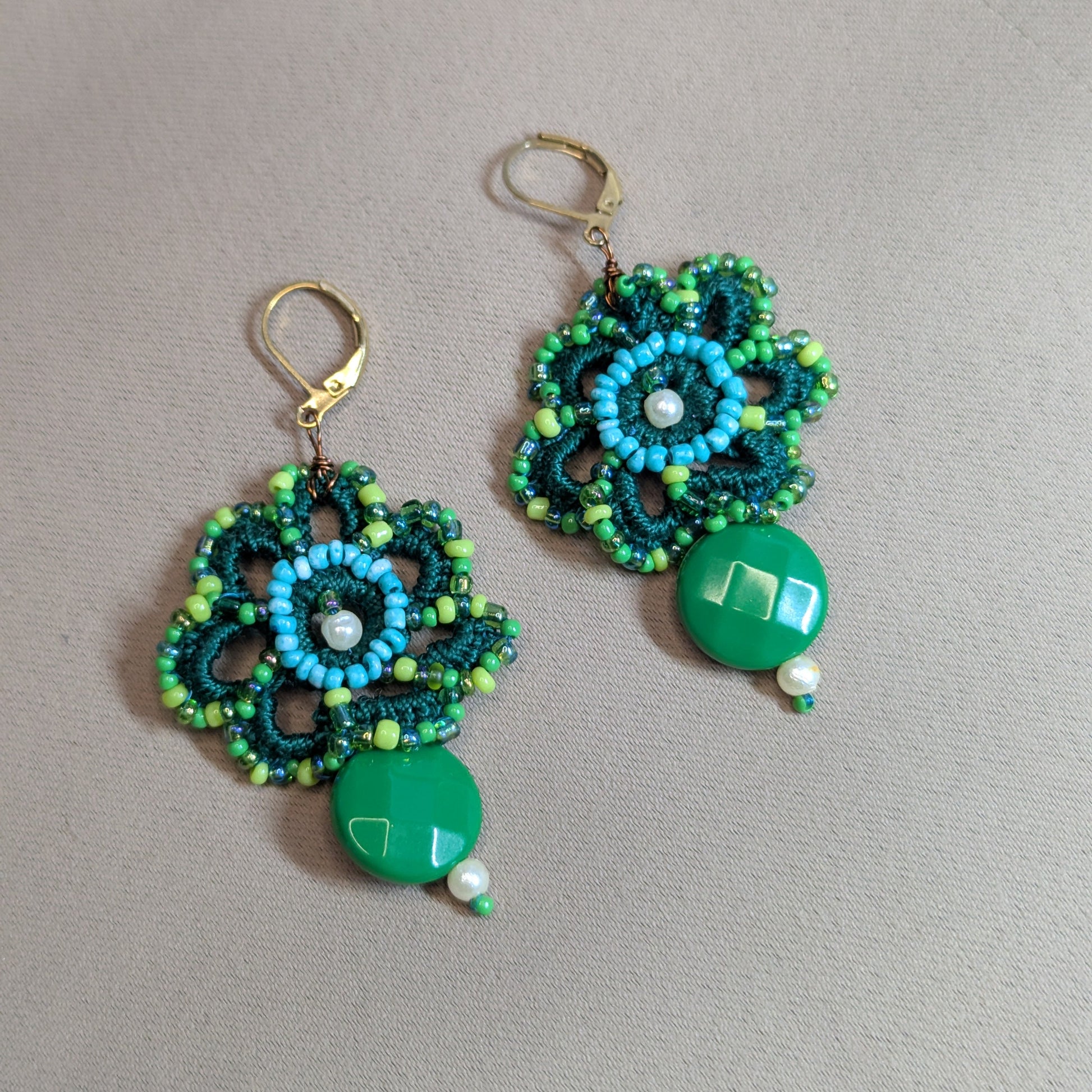 Handcrafted green floral beaded earrings by Mayaani Jewellery featuring vintage green bead drop, turquoise seed bead centre and gold stainless steel clasps on a neutral backdrop.