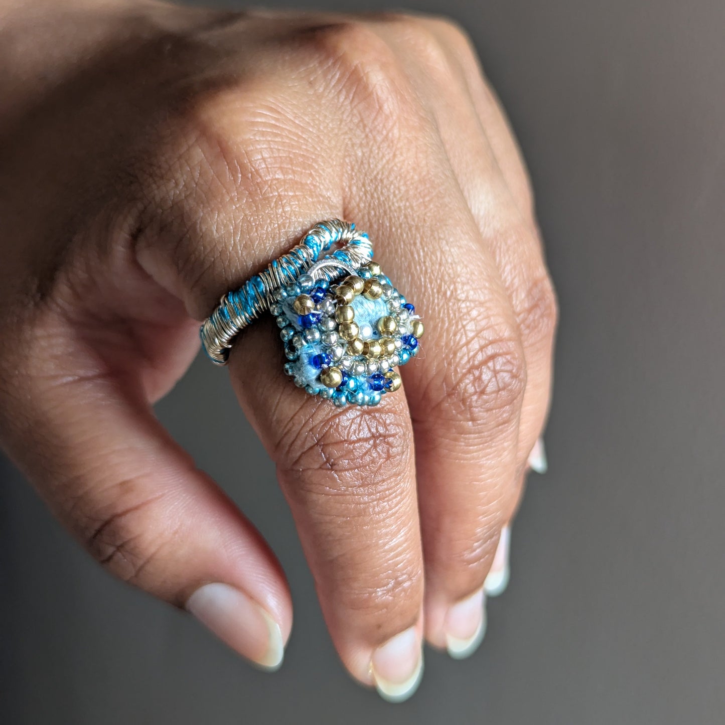 Nira ring element worn as a standalone cocktail ring - blue and gold beaded ring by sustainable brand Mayaani Jewellery UK.