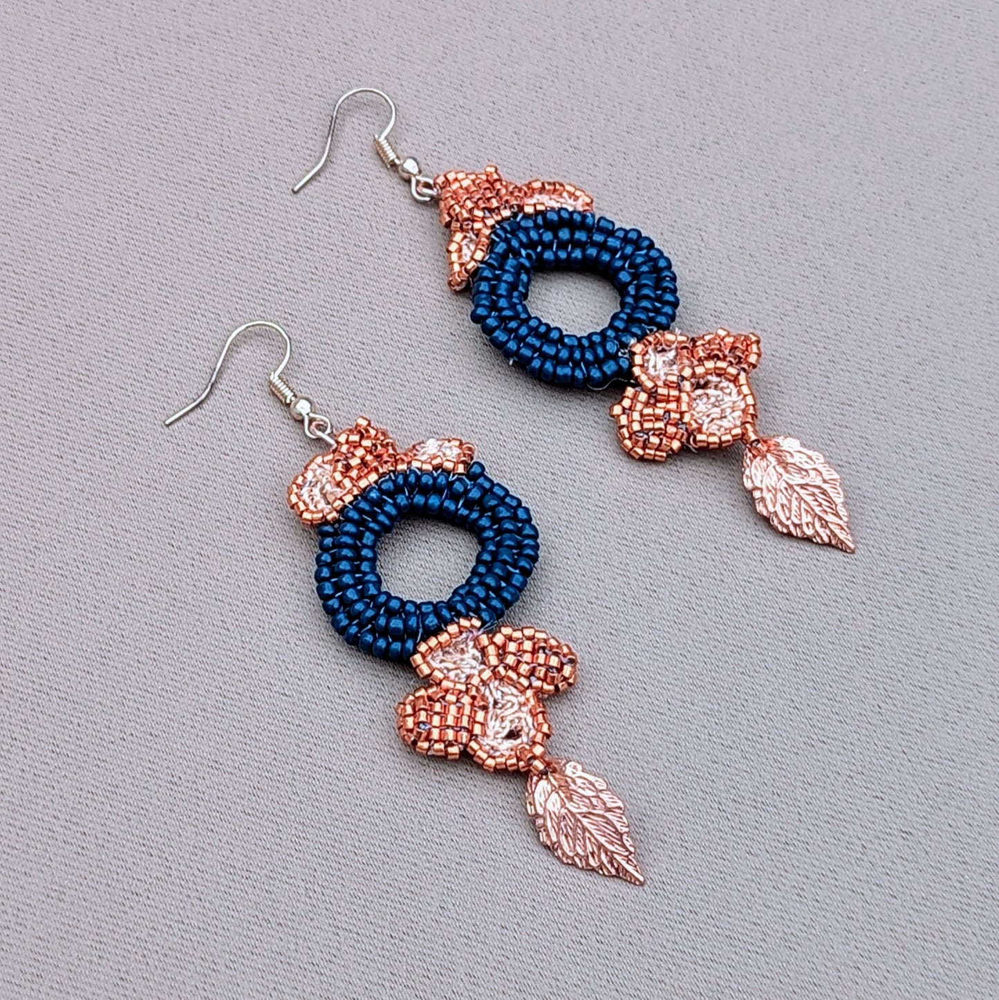 Side profile view of a one-of-a-kind slow handcrafted pair of blue, copper and gold statement earrings exclusive to Mayaani Jewellery UK.