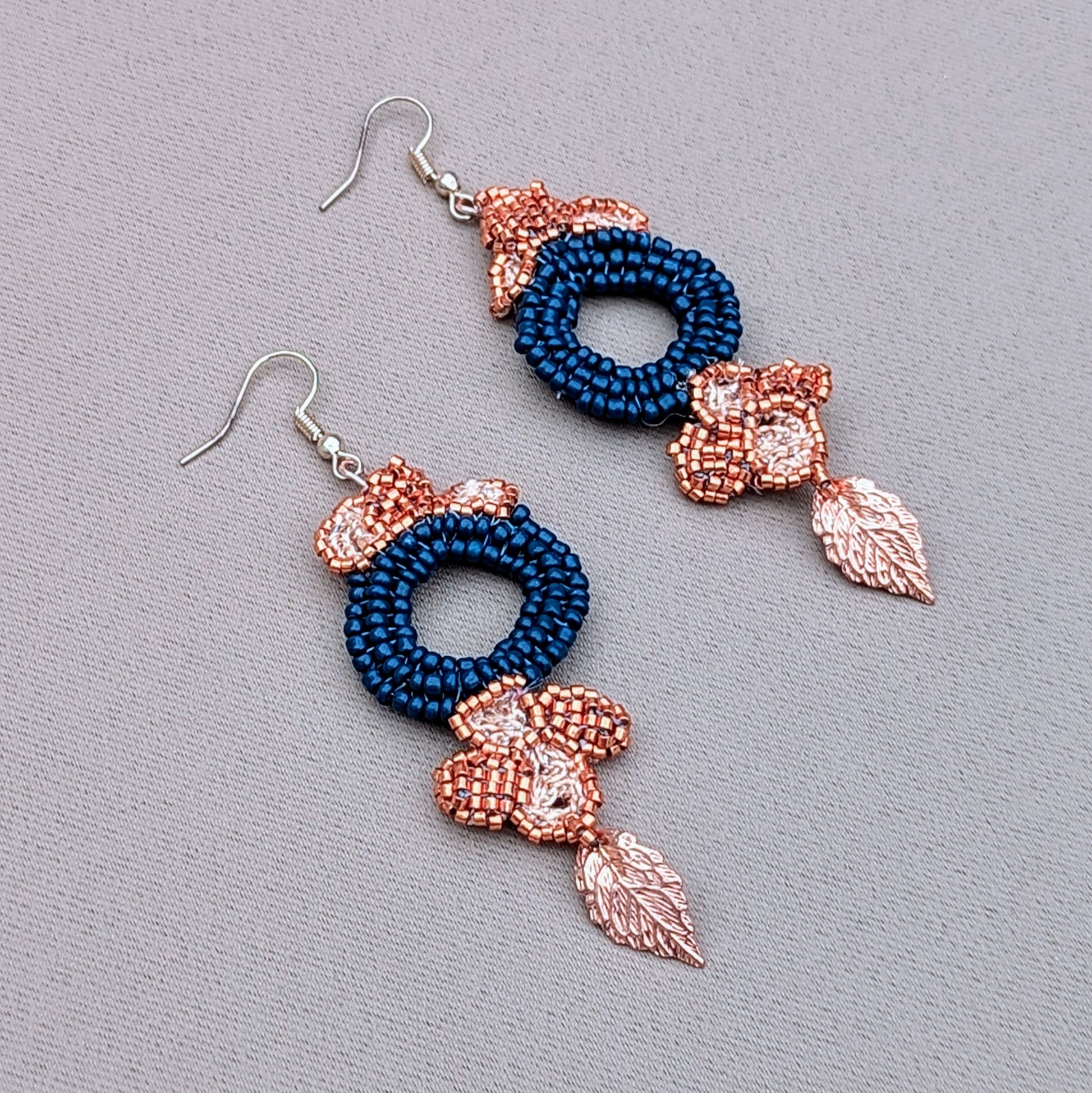 Side profile view of a one-of-a-kind slow handcrafted pair of blue, copper and gold statement earrings exclusive to Mayaani Jewellery UK.