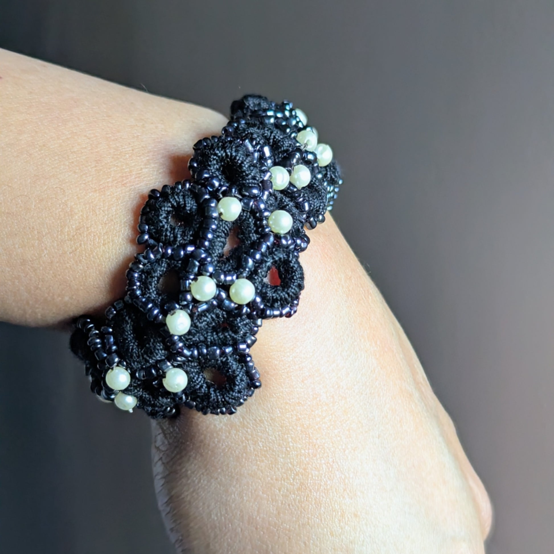 Close-up of the Nisha black crochet bracelet on wrist, with vintage seed pearls and glass beads softly catching the light.