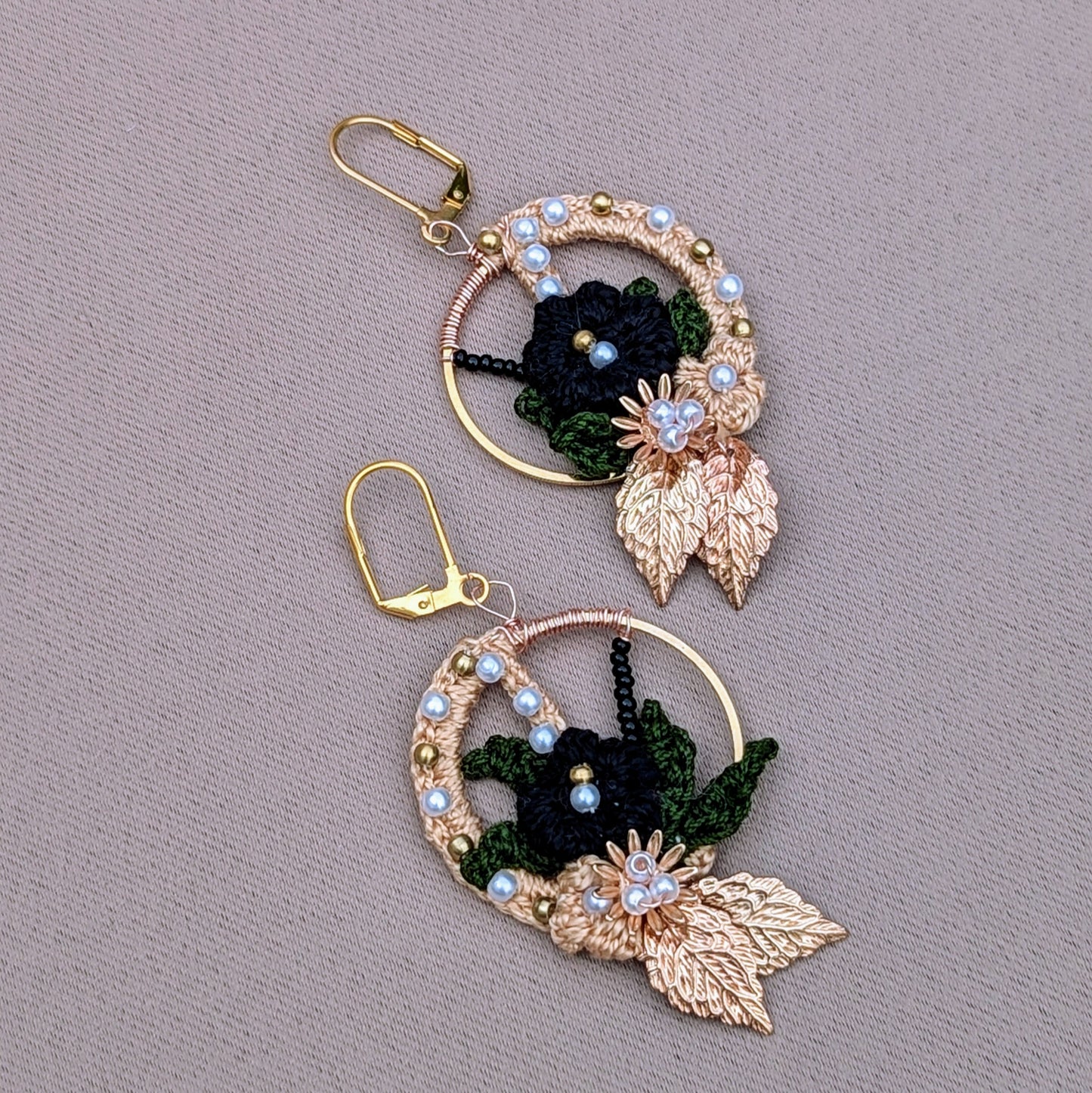 One-of-a-kind Mayaani Jewellery Aloki hoops featuring black and olive crochet flowers with pearls and golden accents.