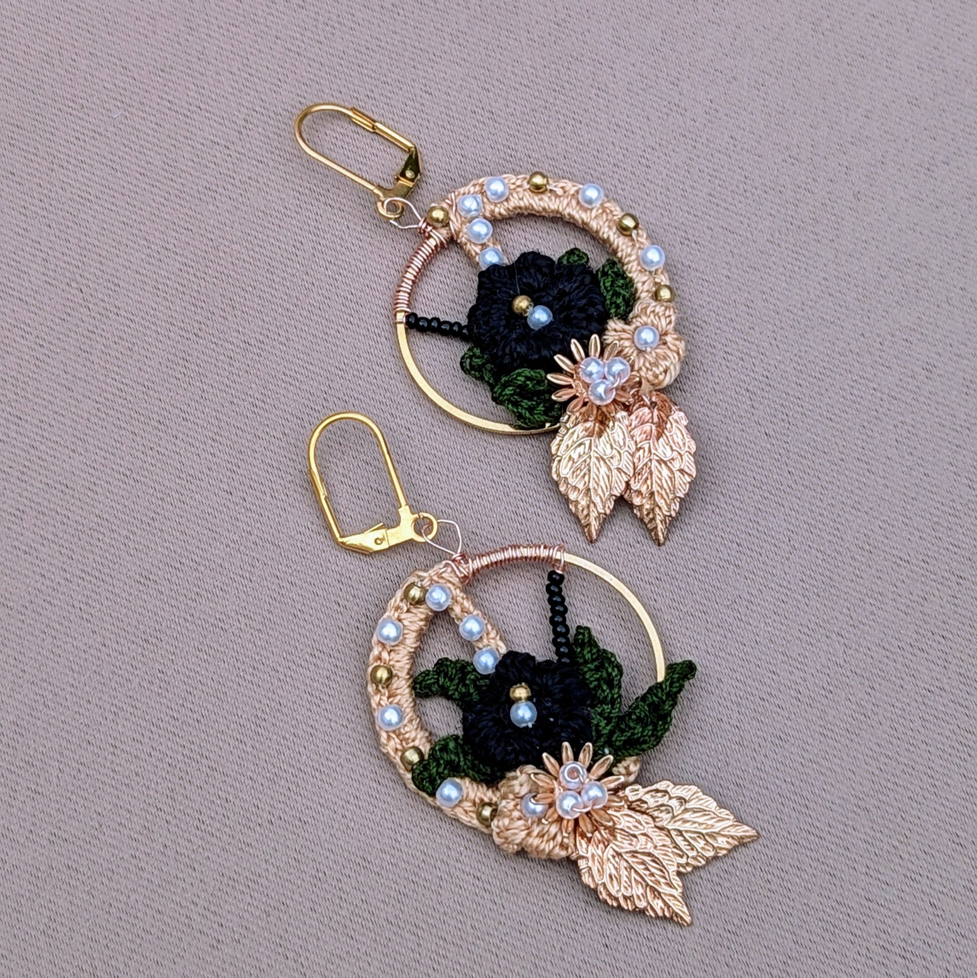 One-of-a-kind Mayaani Jewellery Aloki hoops featuring black and olive crochet flowers with pearls and golden accents.