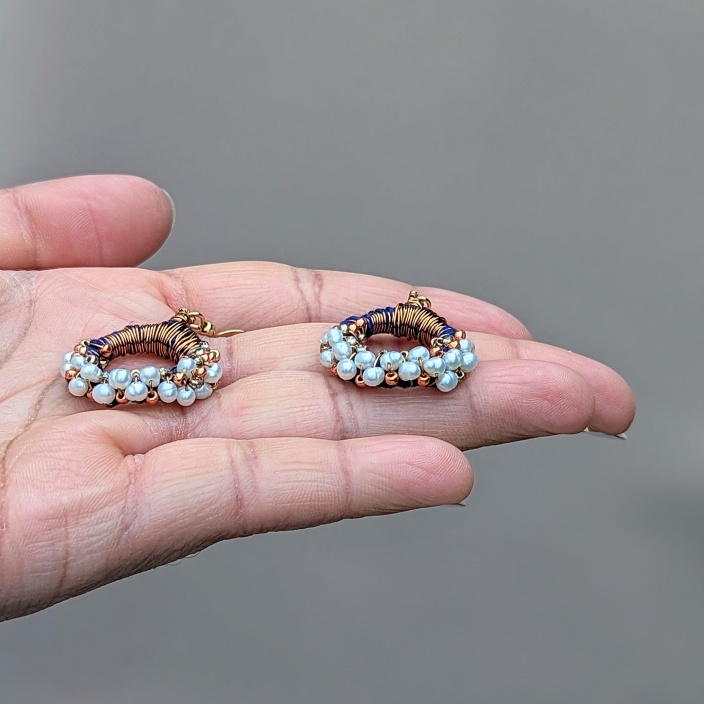 One-of-a-kind handmade earrings with Grade A freshwater pearls and copper wire wrapping, accented with Japanese Miyuki seed beads in blue.