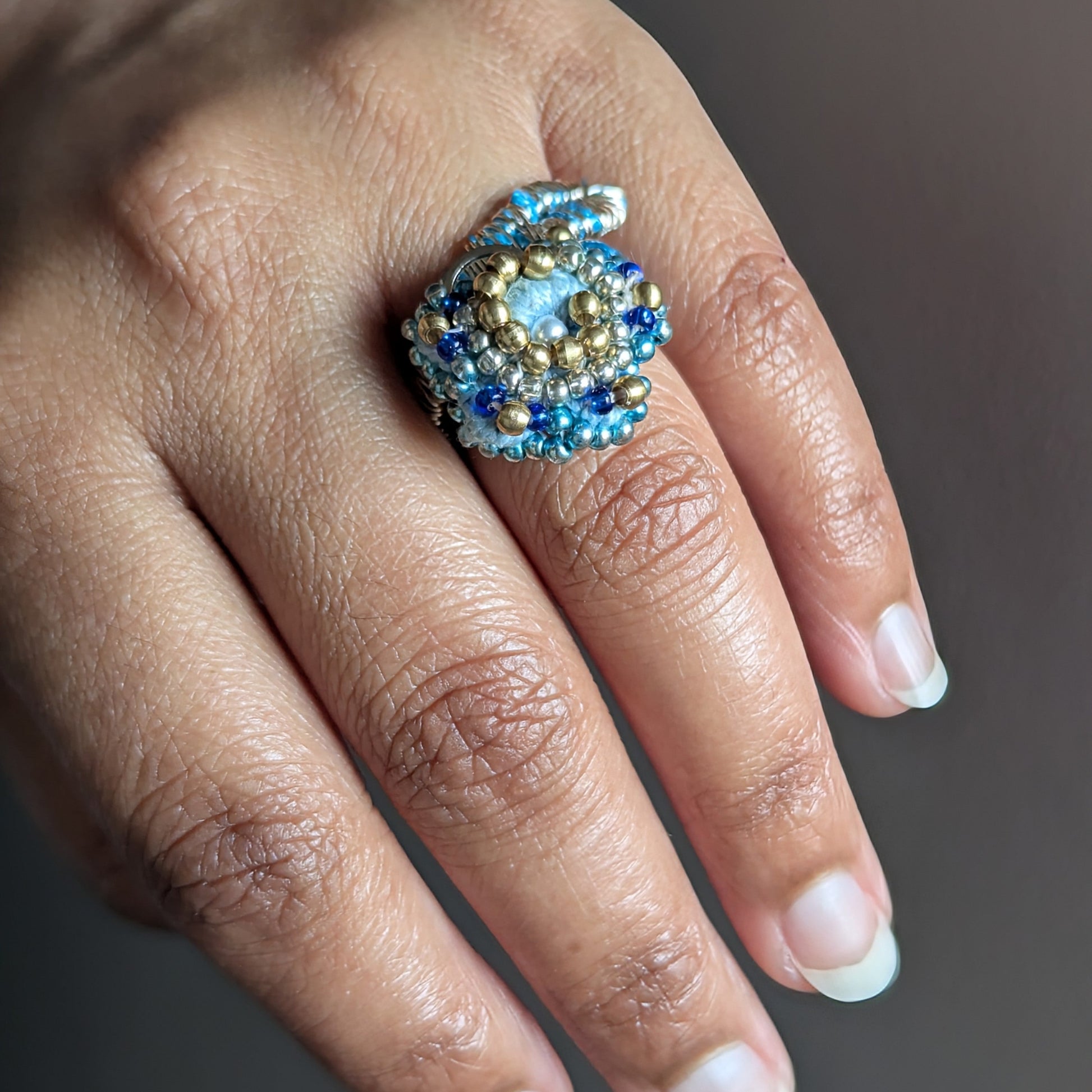 Nira adjustable ring element close up worn on finger - cobalt blue and gold Japanse Miyuki bead embroidery by Mayaani Jewellery UK.