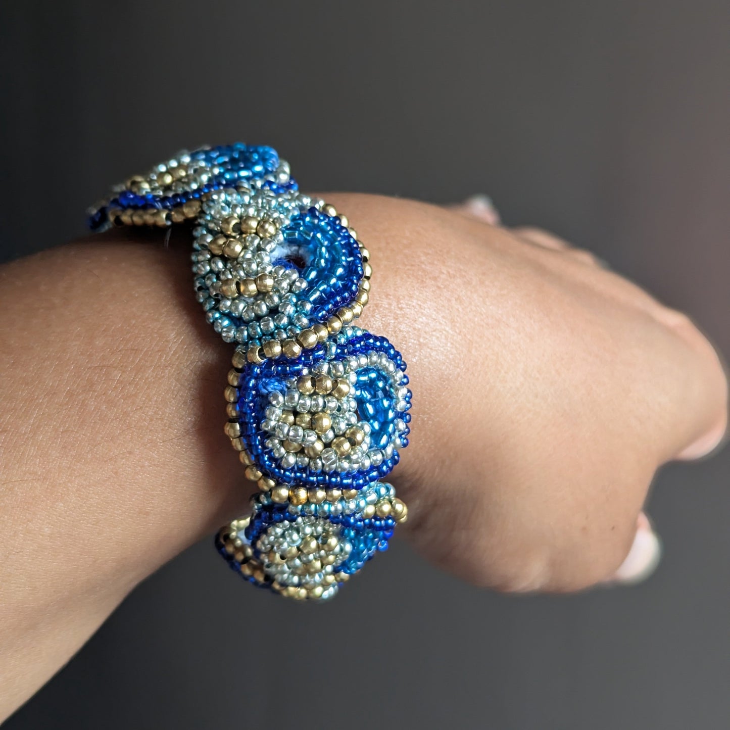 Nira worn as a statement bracelet - 5-in-1 handmade blue and gold beaded bracelet by Mayaani Jewellery UK.