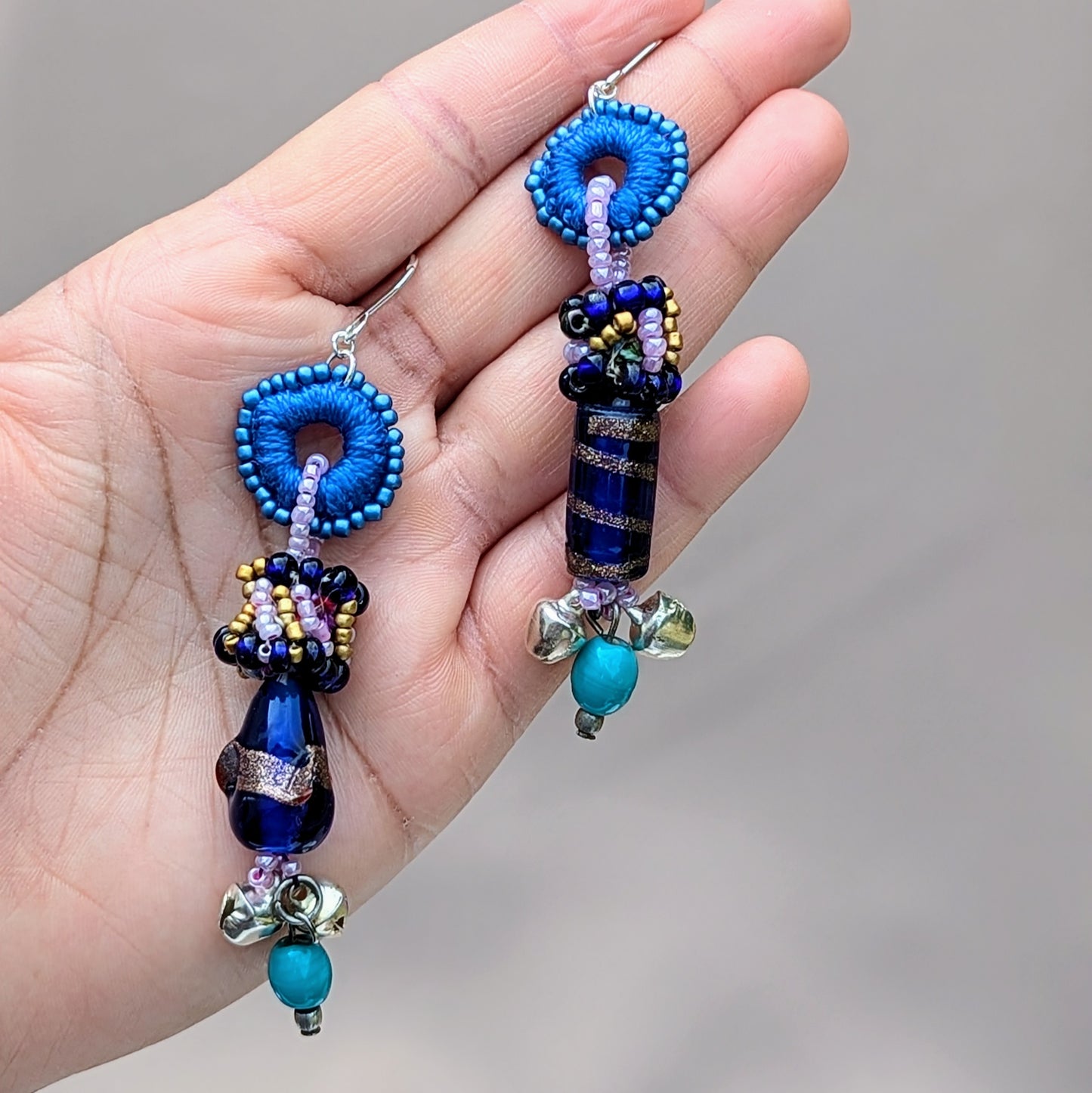 Handcrafted asymmetrical earrings in ocean blues with recycled scrap beads, crochet and bead embroidery details.
