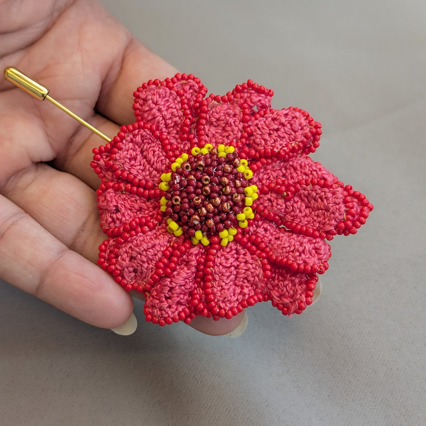 Unique hand made crochet and bead Zinnia flower sustainable fashion statement brooch lapel hat pin exclusive to UK Indian luxury brand Mayaani Jewellery.