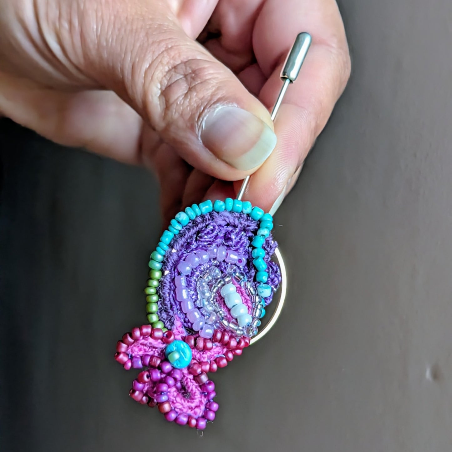 Detailed front view of Navira reimagined textile brooch showing intricate bead embroidery, triple mercerised cotton threads and sculptural circular design.