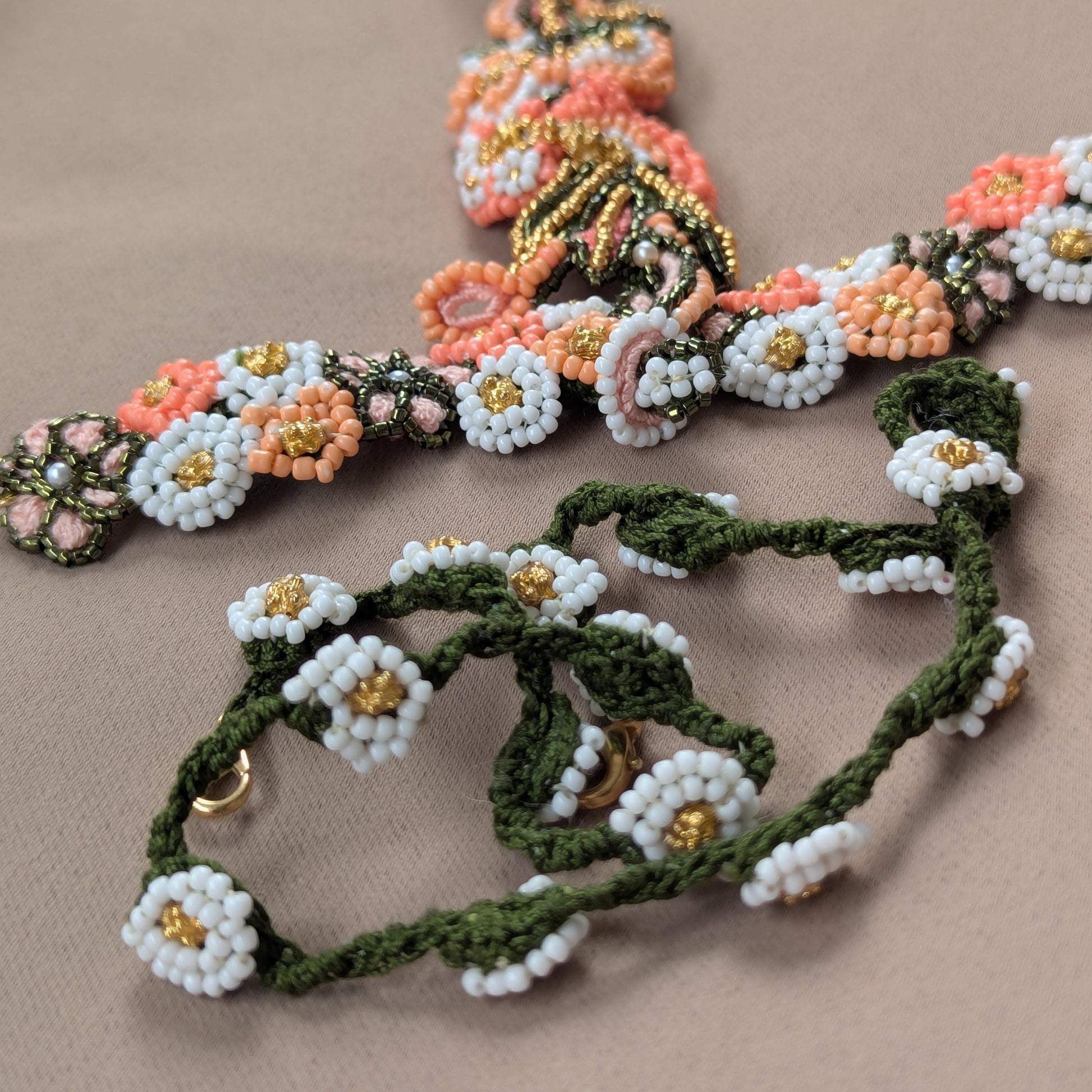 Flat lay view of the Padmika one of a kind 5-in-1 iconic Indian hand bracelet with custom bead crochet chain in green and white featuring vintage gold bead accents