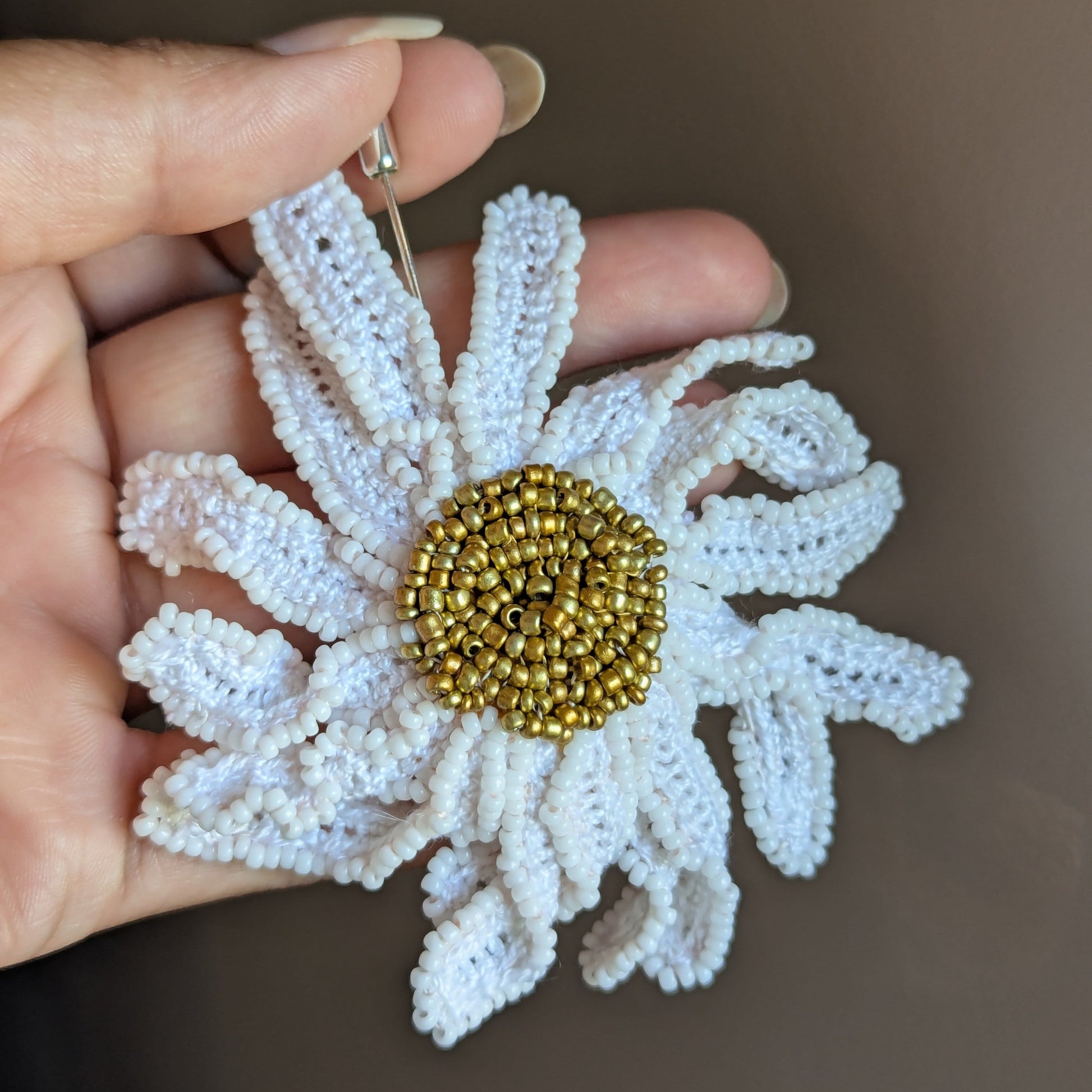 A textural daisy flower brooch pin capturing the movement of petals in a wearable art piece designed and made for Mayaani Jewellery UK.