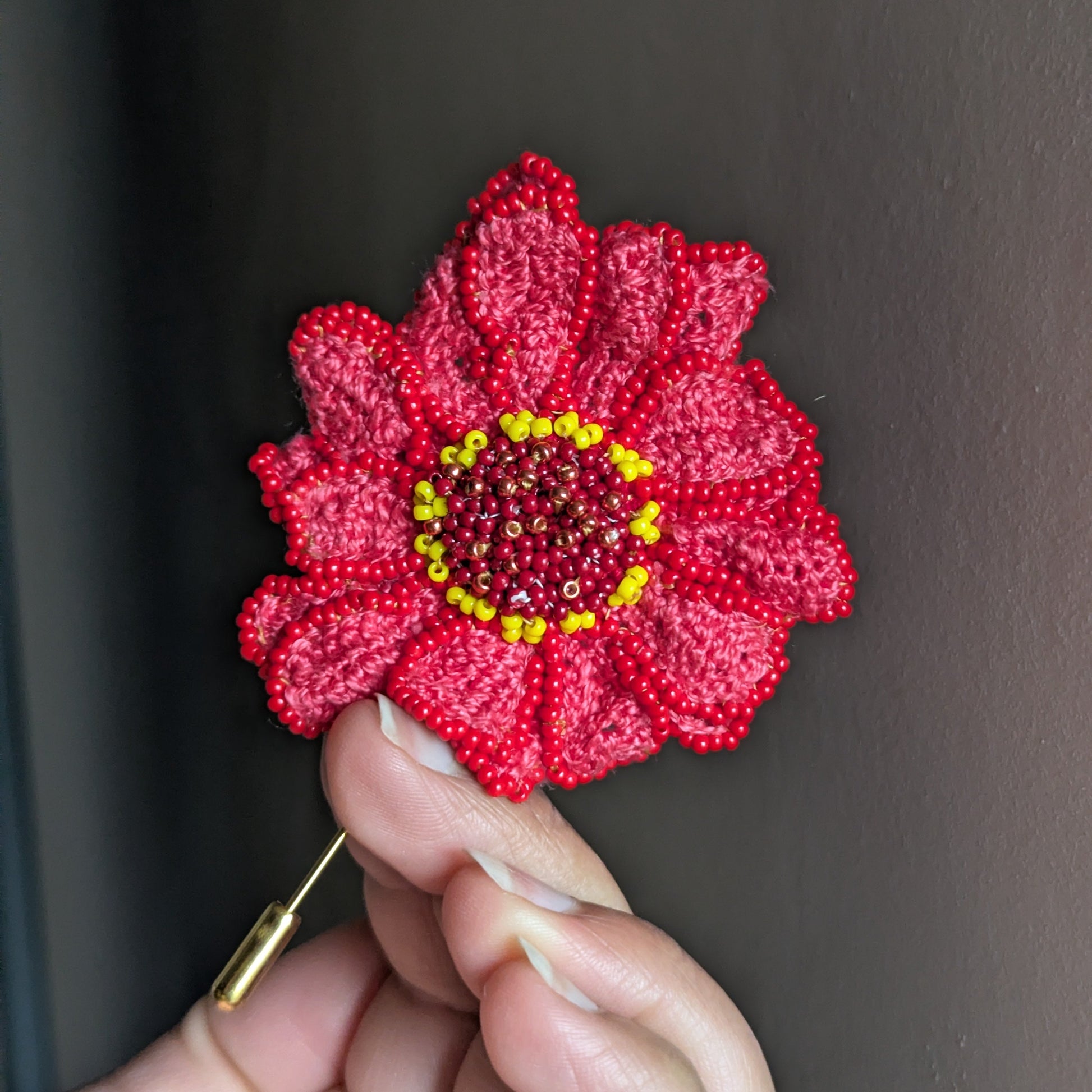 Large floral pink Zinnia brooch pin featuring a gold stick pin created by hand in the UK by Indian artisan Megha of Mayaani Jewellery as part of the Garden of Becoming series of pins sharing the story of rising feminine energies.