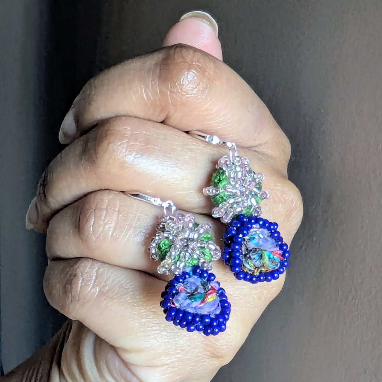 Gaia earrings photographed in soft daylight, revealing shimmering silver-lined pink beads and rich colour contrast.