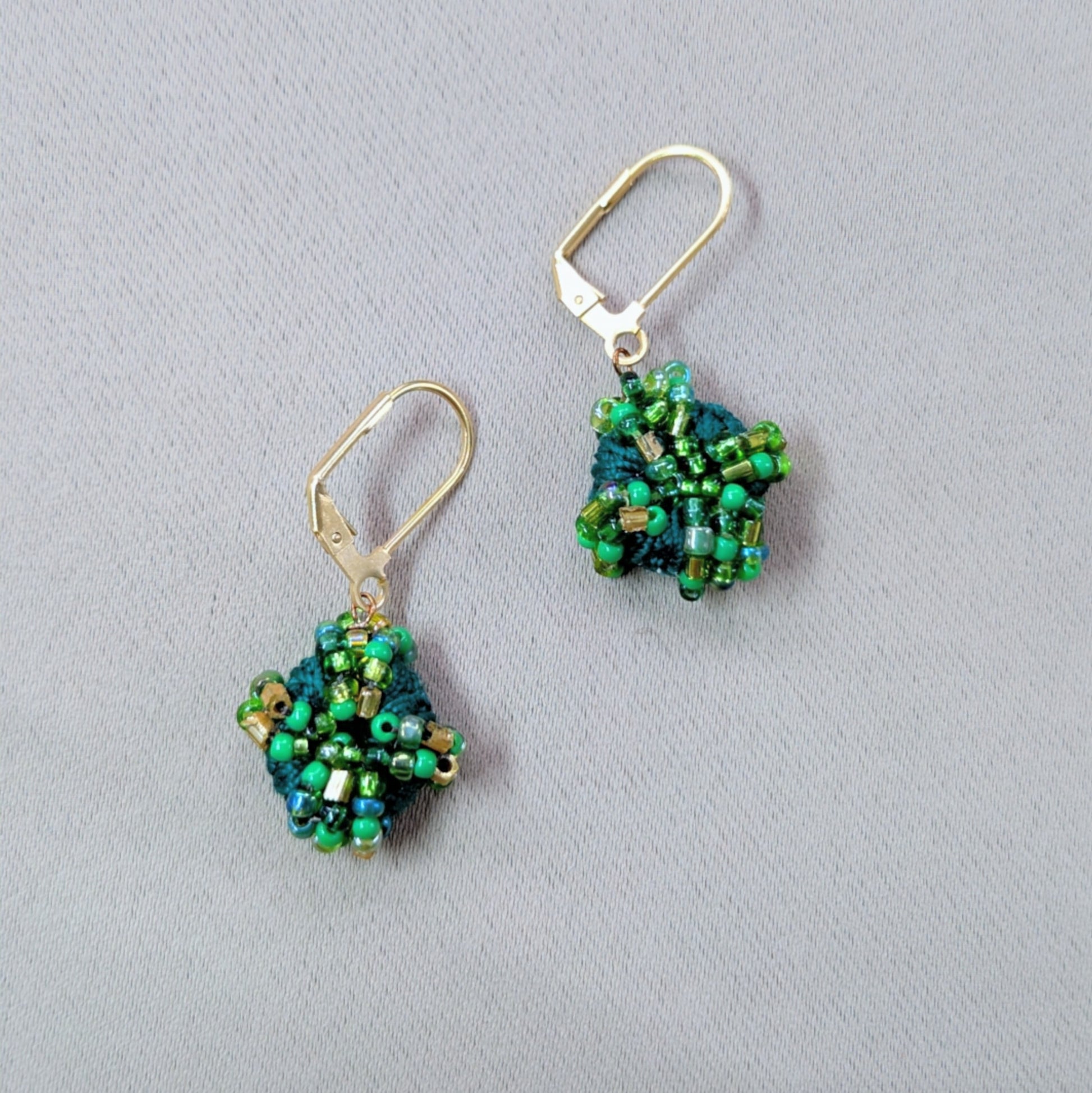 Close up of a pair of expertly handcrafted Indian heritage inspired everyday earrings featuring vintage glass seed beads.