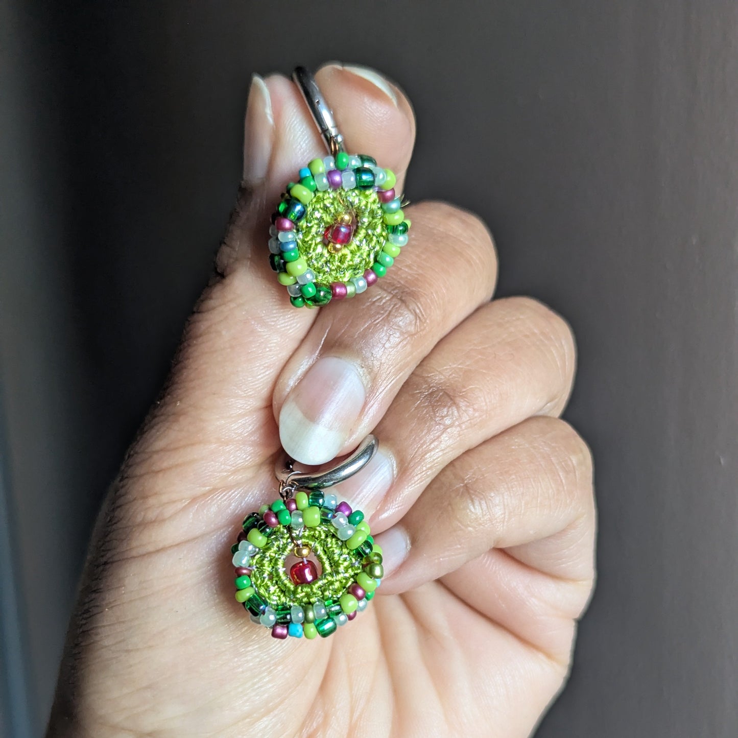 Vana garden-inspired earrings shown in hand for scale, demonstrating petite everyday size, lightweight feel, and detailed artisan beadwork.