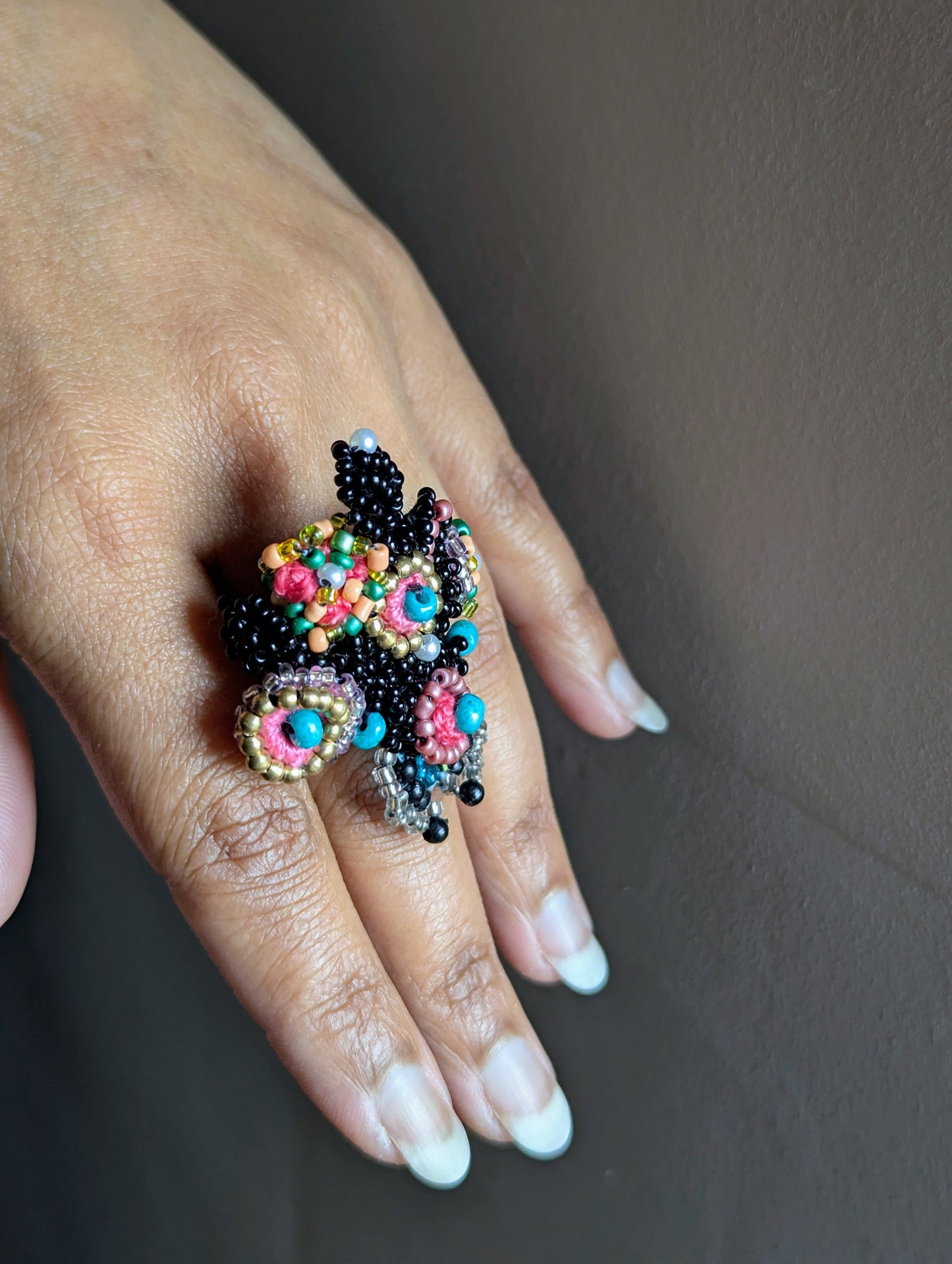 Versatile handmade statement beaded ring in black, turquoise, pink and gold featuring vintage upcycled beads in line with the ethos of sustainable UK brand Mayaani Jewellery.